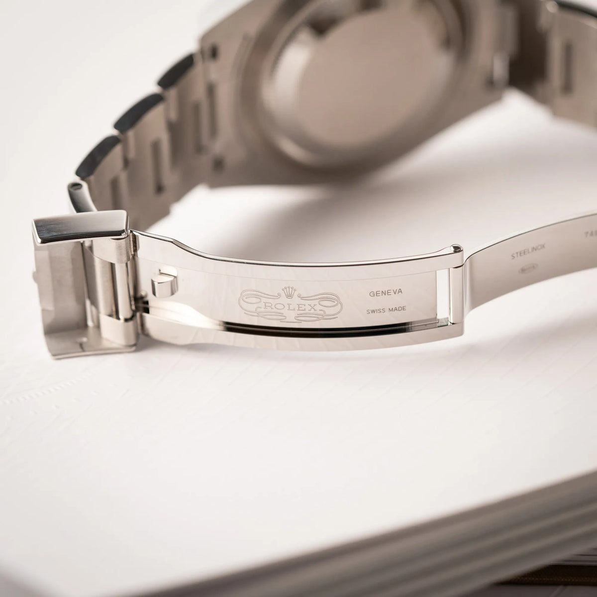 Detailaufnahme der geöffneten Faltschliesse zeigt das klassische Rolex-Logo im Inneren der Schliesse von der Rolex Submariner No Date der Referenz 124060 mit schwarzem Zifferblatt und schwarzer Keramik-Lünette an einem Oytser-Stahlband im Neuzustand