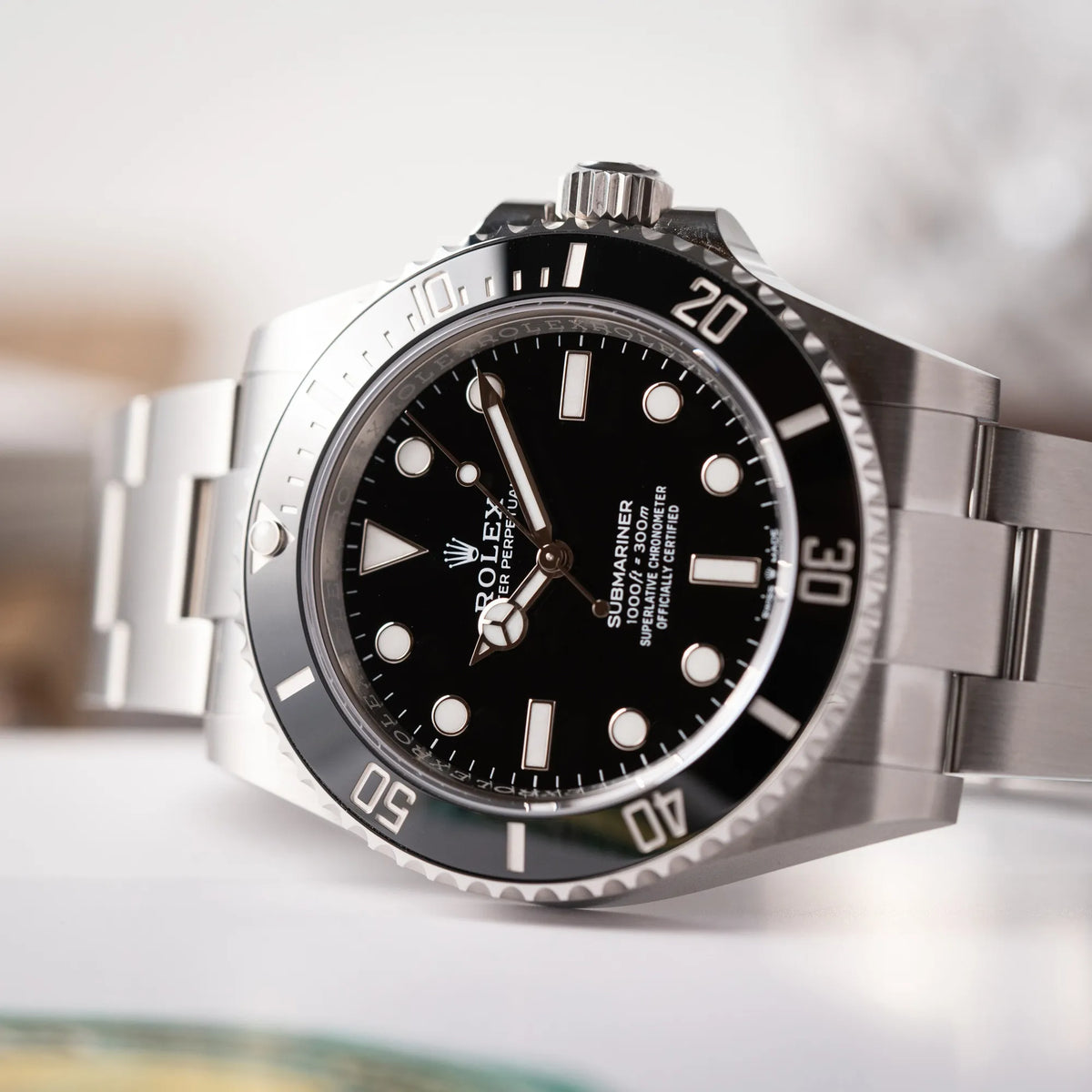Produktfotografie zeigt den Uhrenkopf der Rolex Submariner No Date der Referenz 124060 mit schwarzem Zifferblatt und schwarzer Keramik-Lünette an einem Oytser-Stahlband im Neuzustand