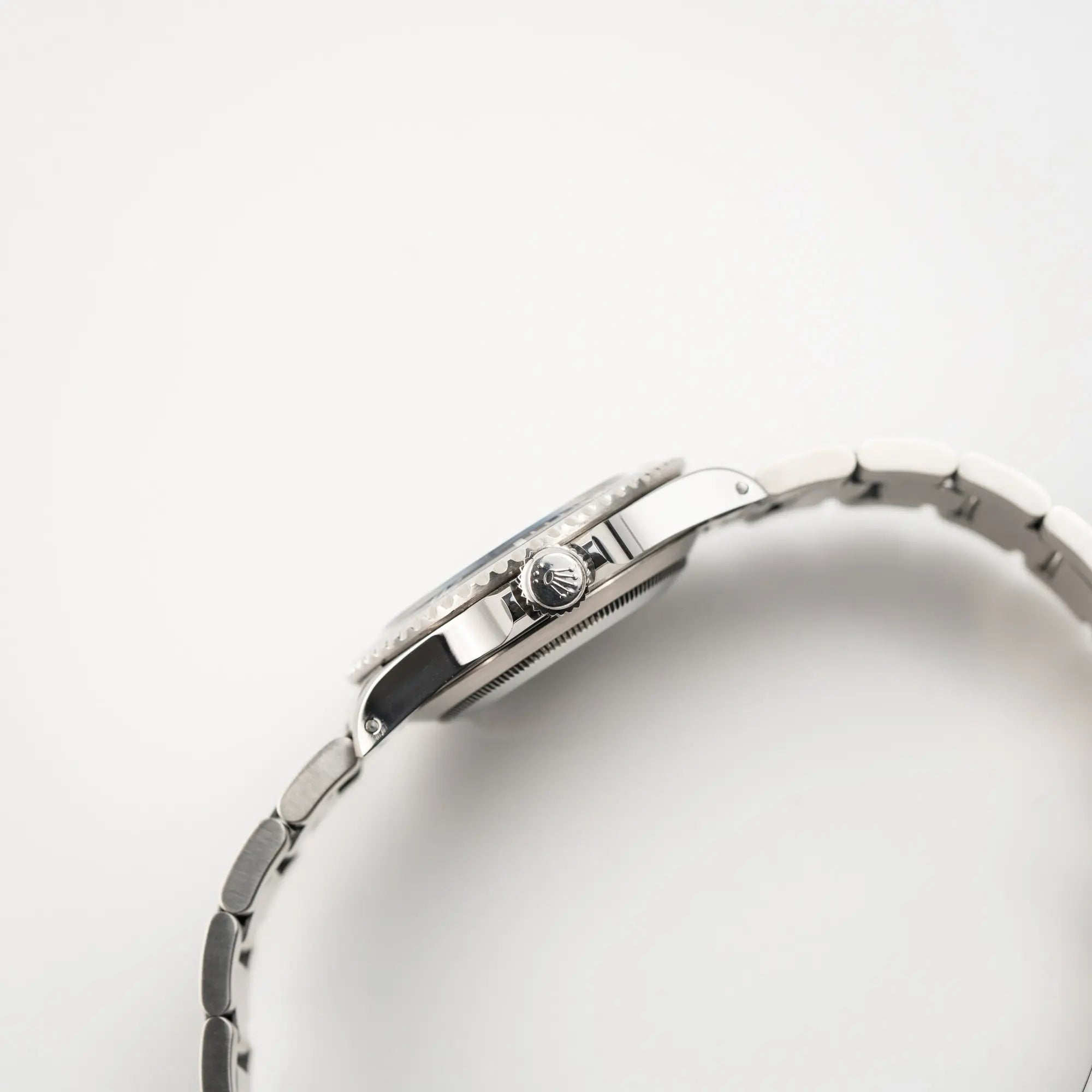 Seitliche Gehäuseflanke der  Rolex Submariner No Date 14060M mit schwarzem Zifferblatt und der klassischen schwarzen Aluminium-Lünette zeigt die Aufzugskrone