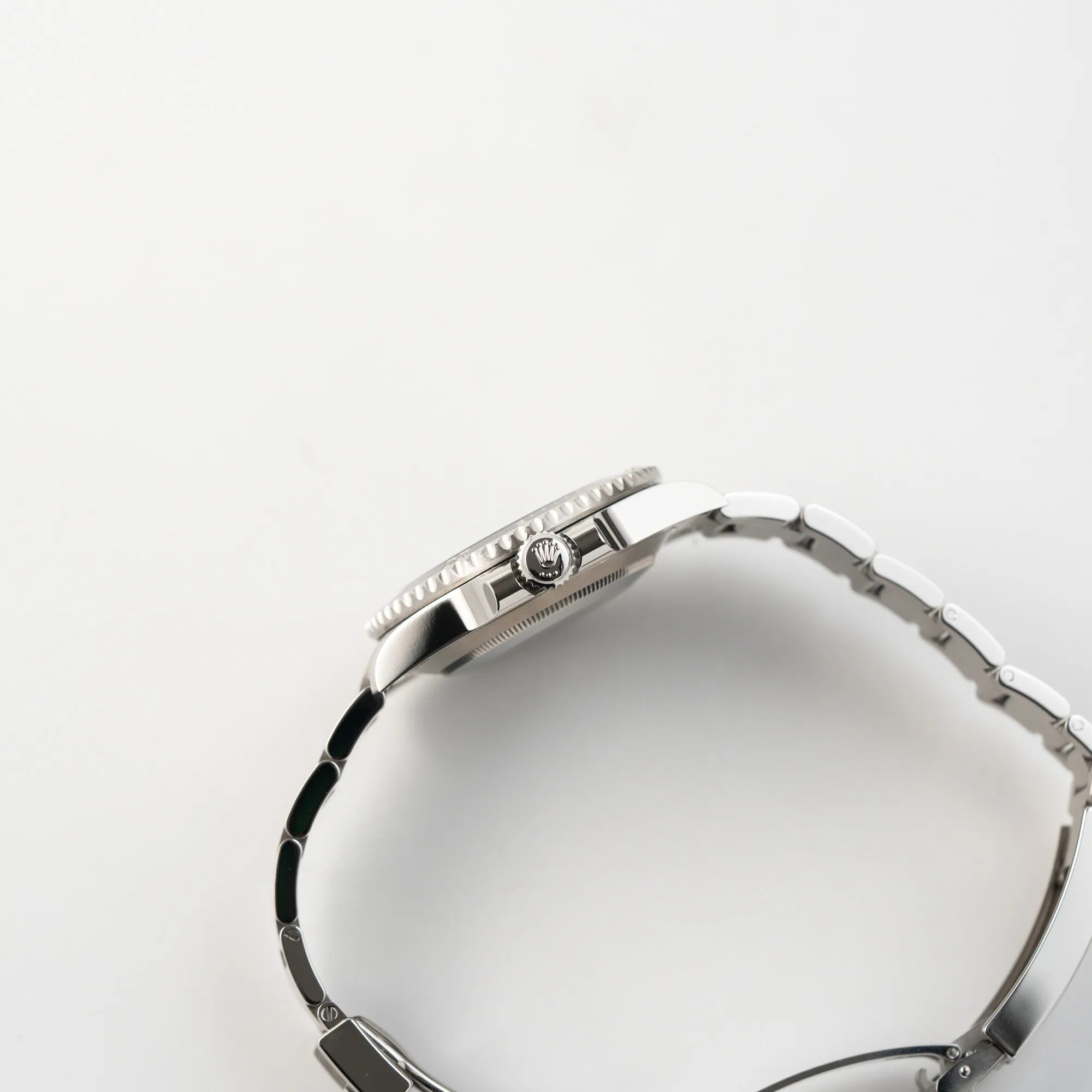 Seitliche Gehäuseflanke der Rolex Submariner 114060 No Date aus 2019 in der klassischen schwarzen Ausführung im Neuzustand mit Blick auf die Aufzugskrone