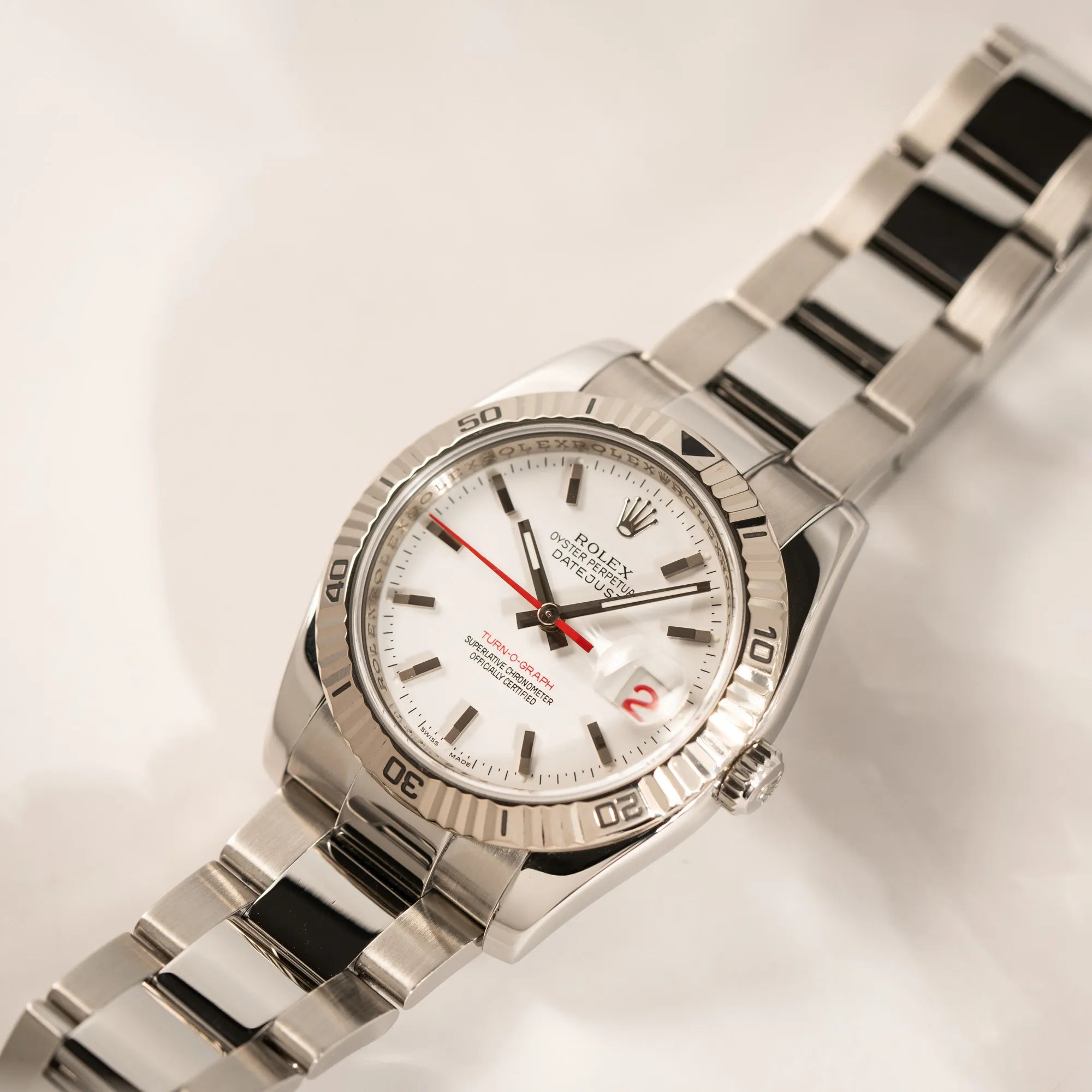 Rolex  Datejust Turn-O-Graph 116264 in 36 mm mit dem weißen Zifferblatt und dem roten Sekundenzeiger  mit spiegelndem Licht in der geriffelten Lünette