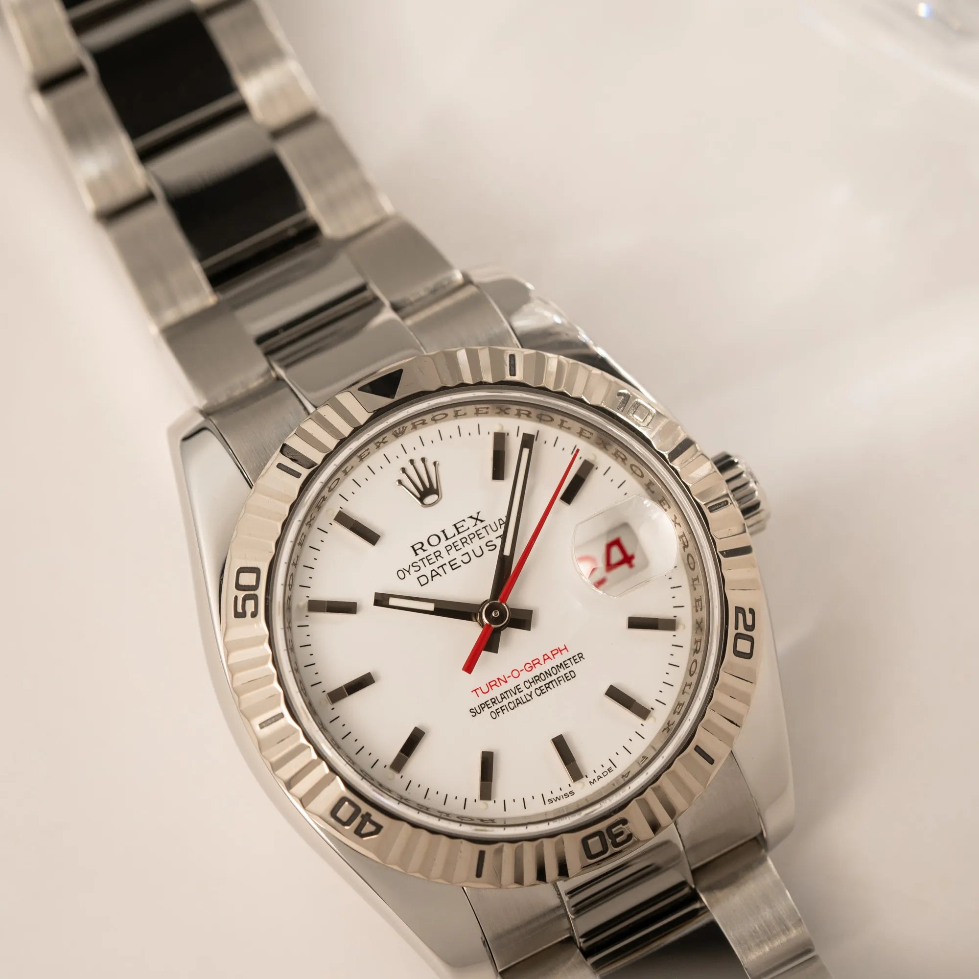 Produktfotografie der Rolex  Datejust Turn-O-Graph 116264 in 36 mm mit dem weißen Zifferblatt und dem roten Sekundenzeiger mit Fokus auf dem Uhrenkopf