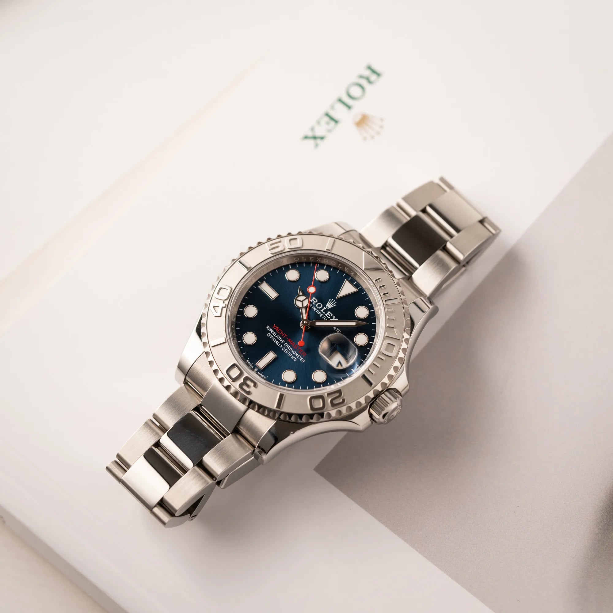 Rolex Yacht-Master 40 der Referenz 126622 mit der Platin-Lünette in der blauen Zifferblatt-Variante auf einem Rolex-Buch