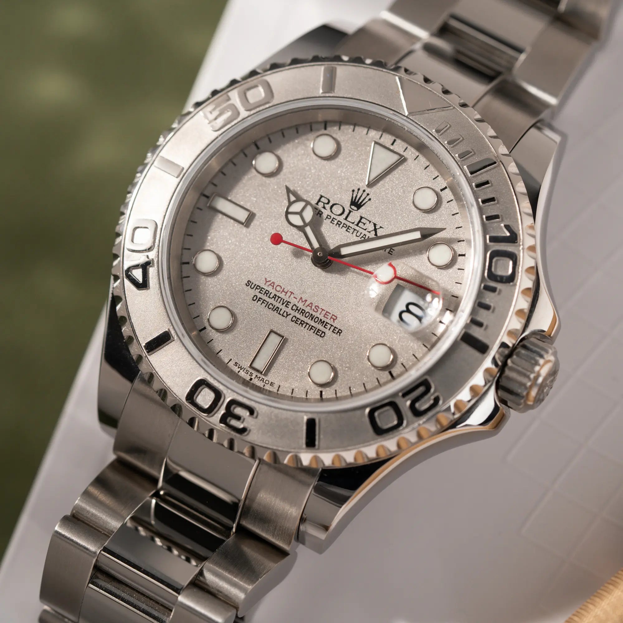 Nahaufnahme des Uhrenkopfes der Rolex Yacht-Master 40 Rolesium der Referenz 16622 mit dem silberfarbenen Platin-Zifferblatt und Platin-Lünette, sowie einem auffälligen in Rot gehaltenen Sekundenzeiger 