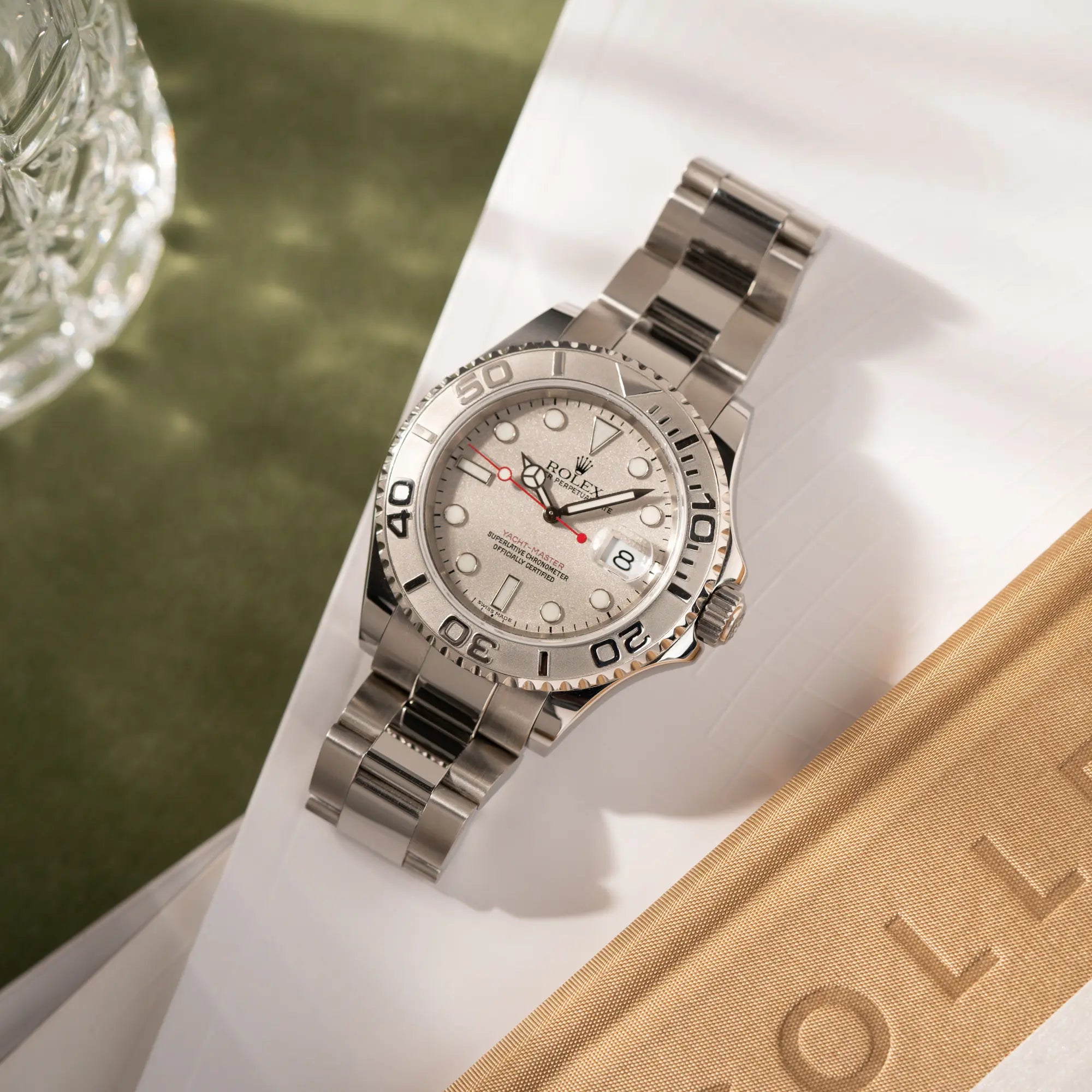 Produktfotografie der Rolex Yacht-Master 40 Rolesium der Referenz 16622 mit dem silberfarbenen Platin-Zifferblatt und Platin-Lünette, sowie einem auffälligen in Rot gehaltenen Sekundenzeiger 