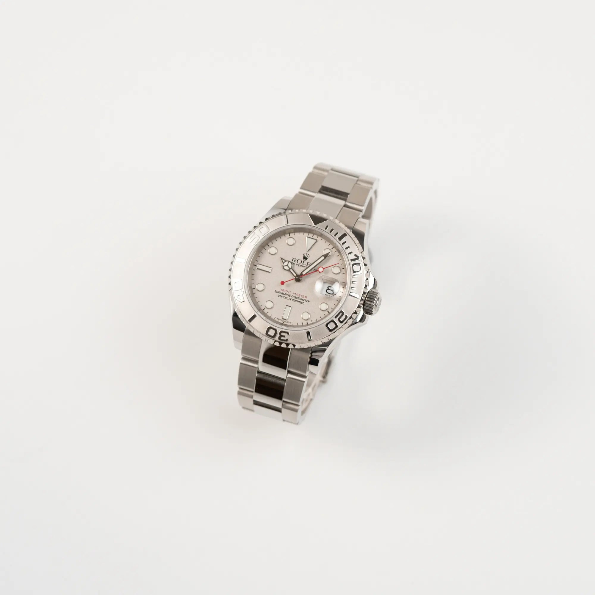 Leicht schräge Ansicht der Rolex Yacht-Master 40 Rolesium der Referenz 16622 mit dem silberfarbenen Platin-Zifferblatt und Platin-Lünette, sowie einem auffälligen in Rot gehaltenen Sekundenzeiger 