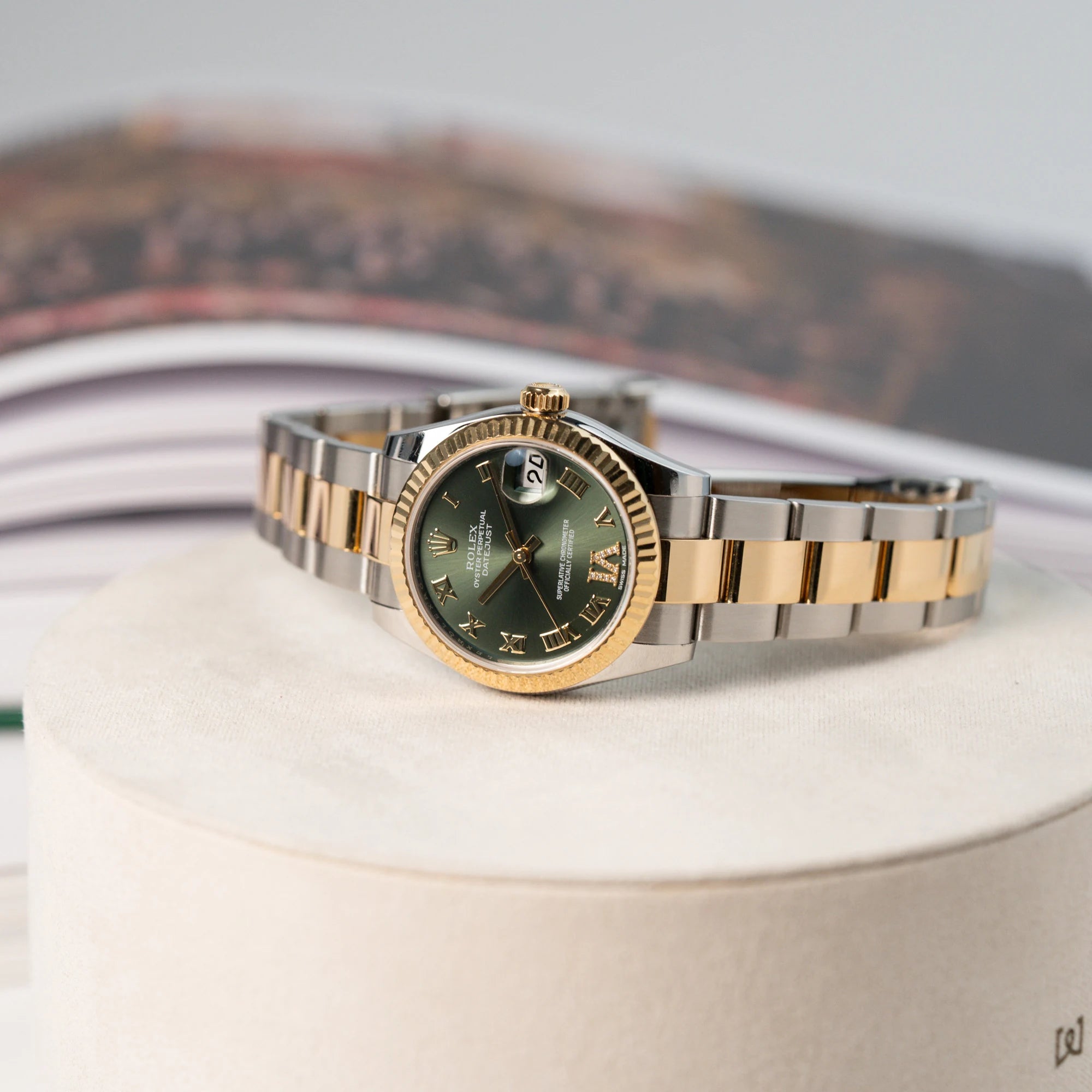 Produktfotografie der liegenden Rolex Datejust 31 mm für Ladies mit einem oliven Zifferblatt und einem diamantbesetzten Index