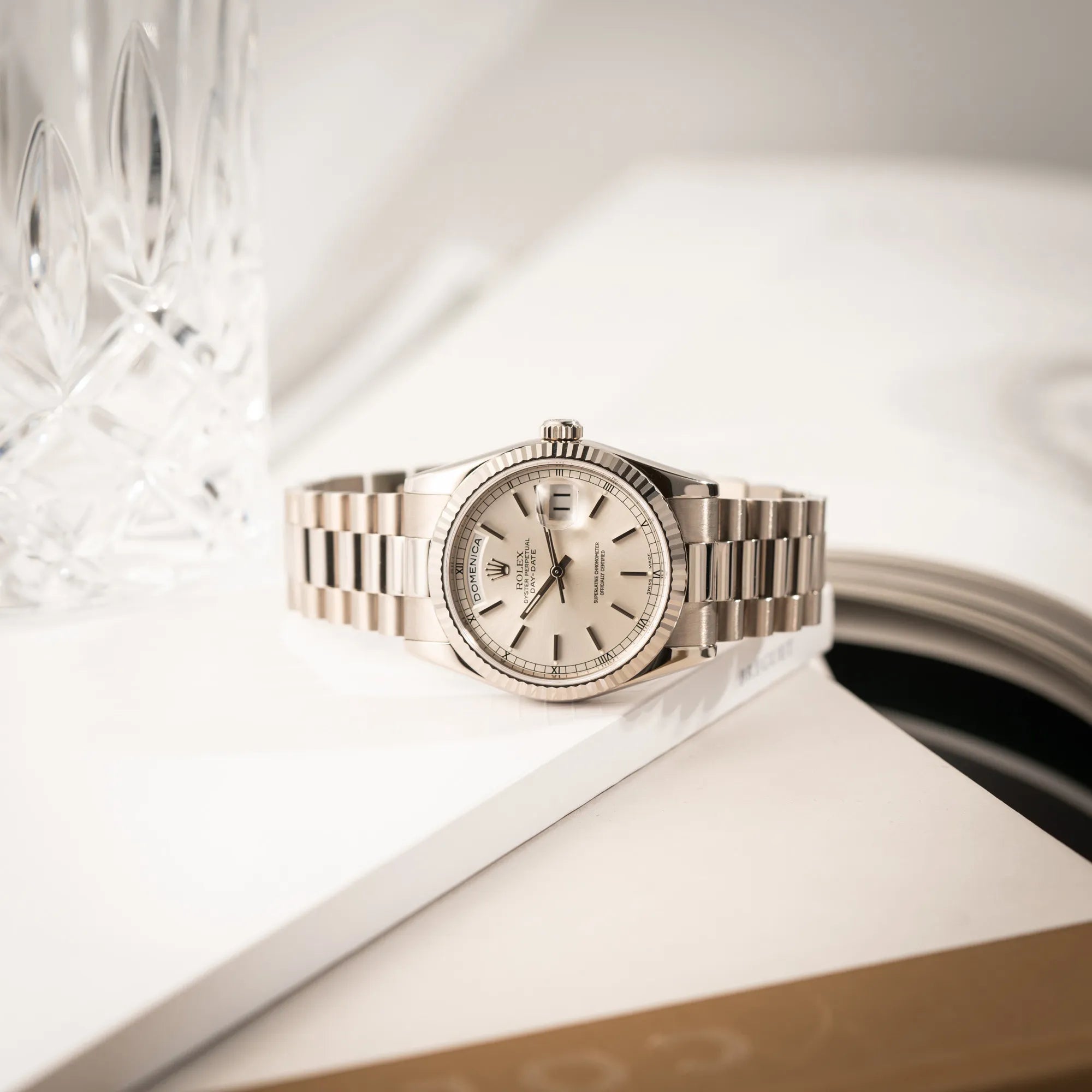 Produktfotografie der seitlich liegenden Rolex Day-Date 36 der Referenz 118239 in 750er Weißgold gefertigt mit dem klassischen President-Armband