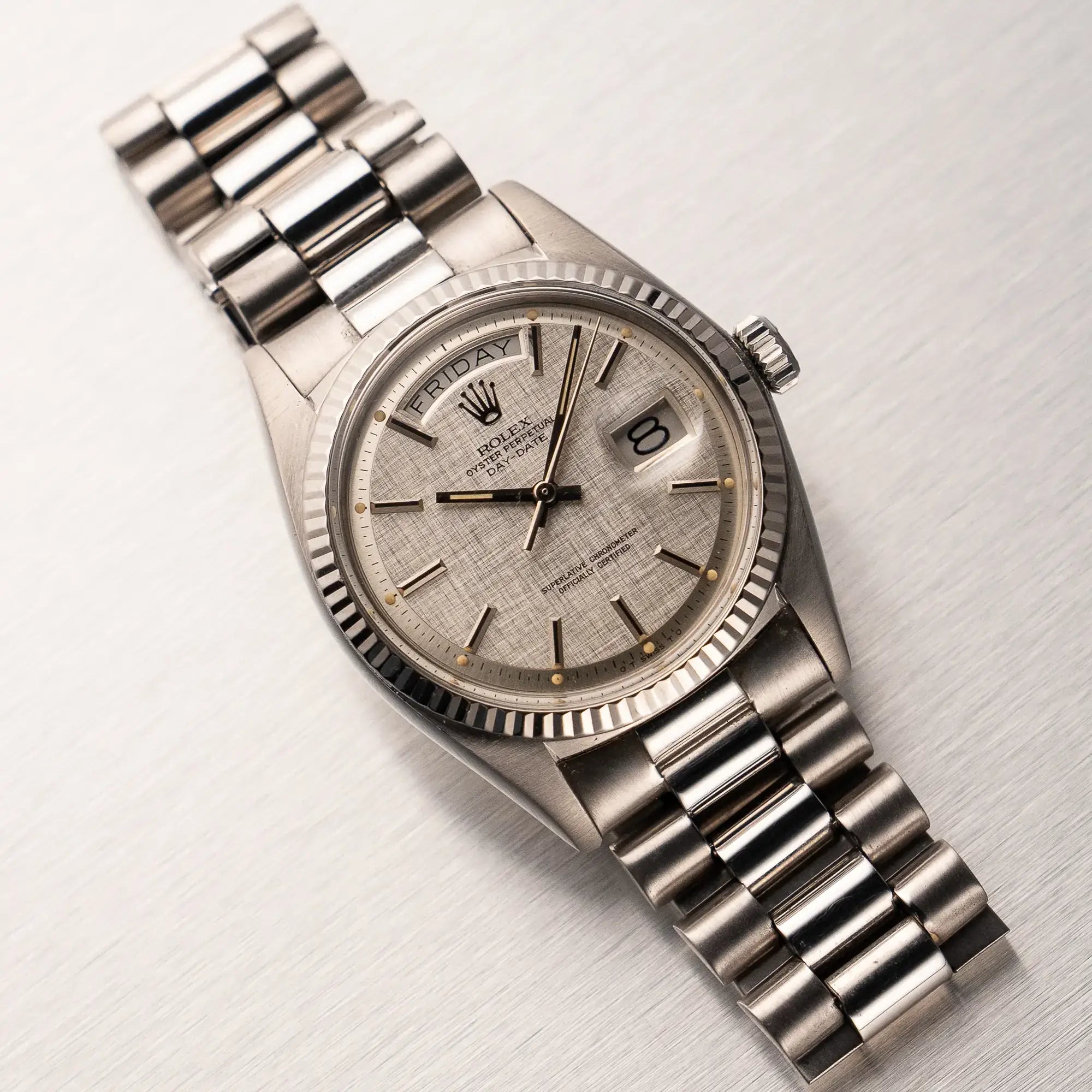 Produktfotografie der Rolex DayDate mit der Referenz 1803  in Weißgold mit 36 mm Durchmesser und einem speziellen Zifferblatt, dass an die Struktur von Leinenstoff erinnert