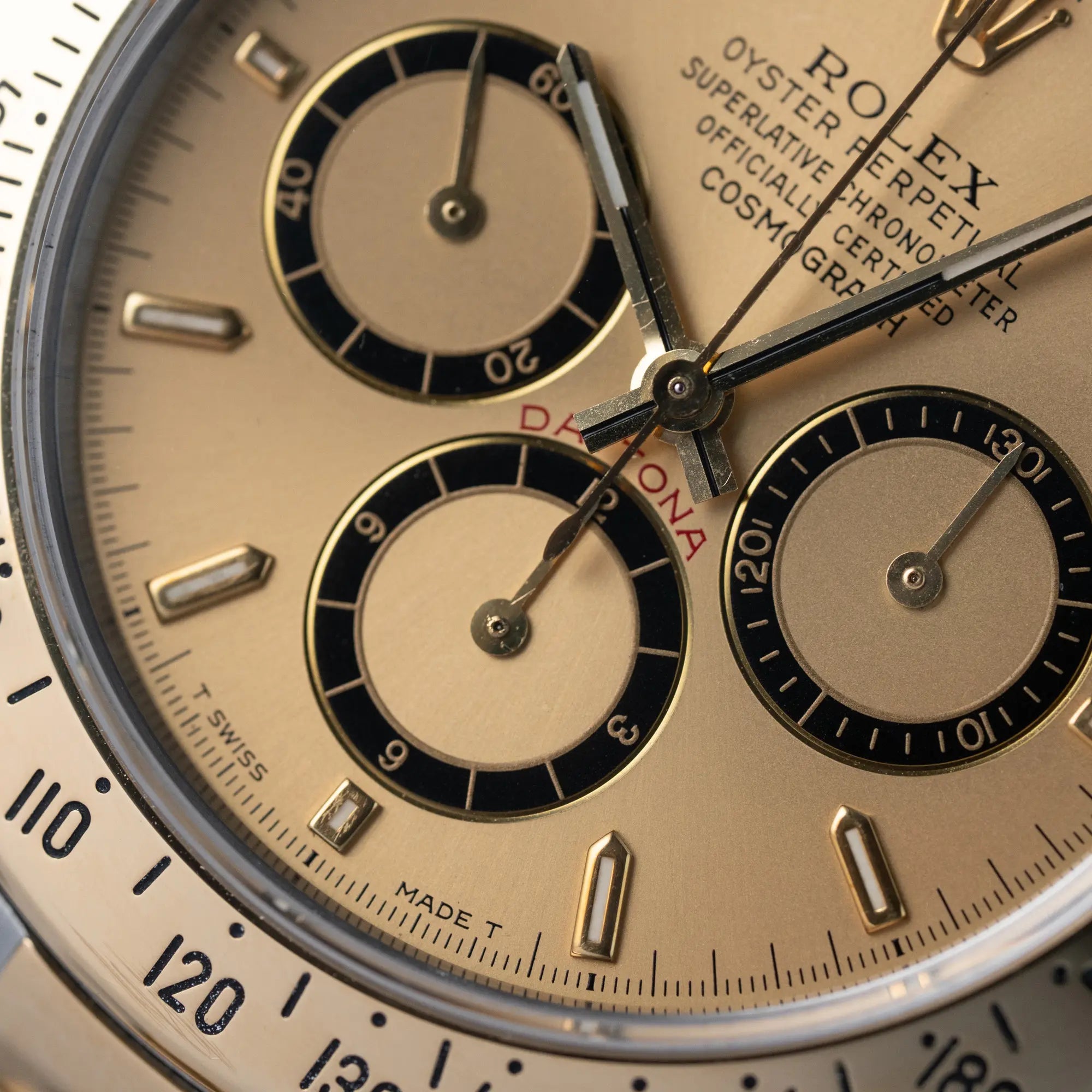 Makroaufnahme des goldfarbenen Zifferblatts der Rolex Zenith Daytona in Stahl-Gold mit Fokus auf den drei Totalisatoren