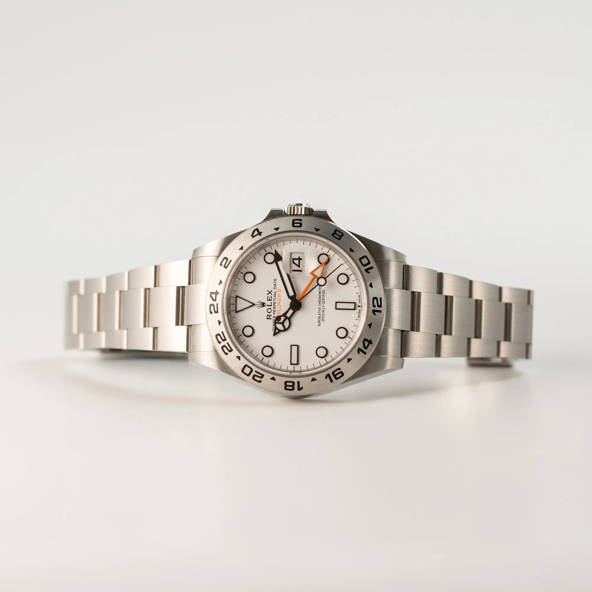 Seitlich auf dem Gehäuse liegende Rolex Explorer II im 42mm Oyster-Gehäuse (Referenz 226570) mit weißem Zifferblatt und orangem GMT-Zeiger