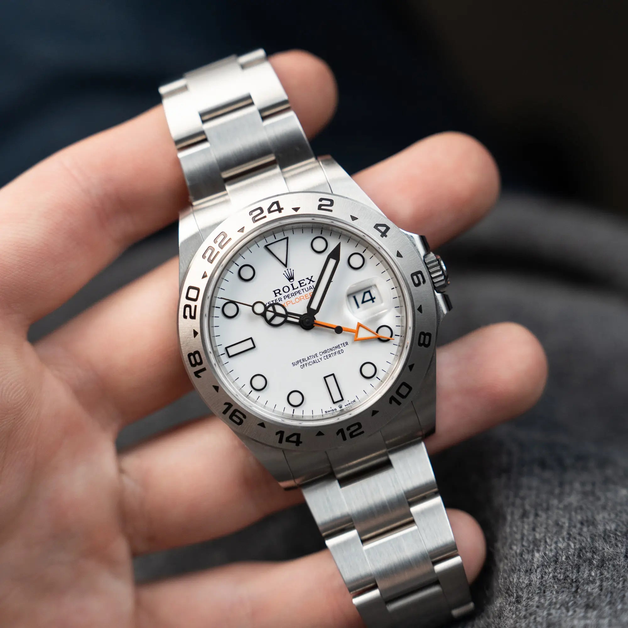 Mann präsentiert die Rolex Explorer II im 42mm Oyster-Gehäuse (Referenz 226570) mit weißem Zifferblatt und orangem GMT-Zeiger ind ie Kamera