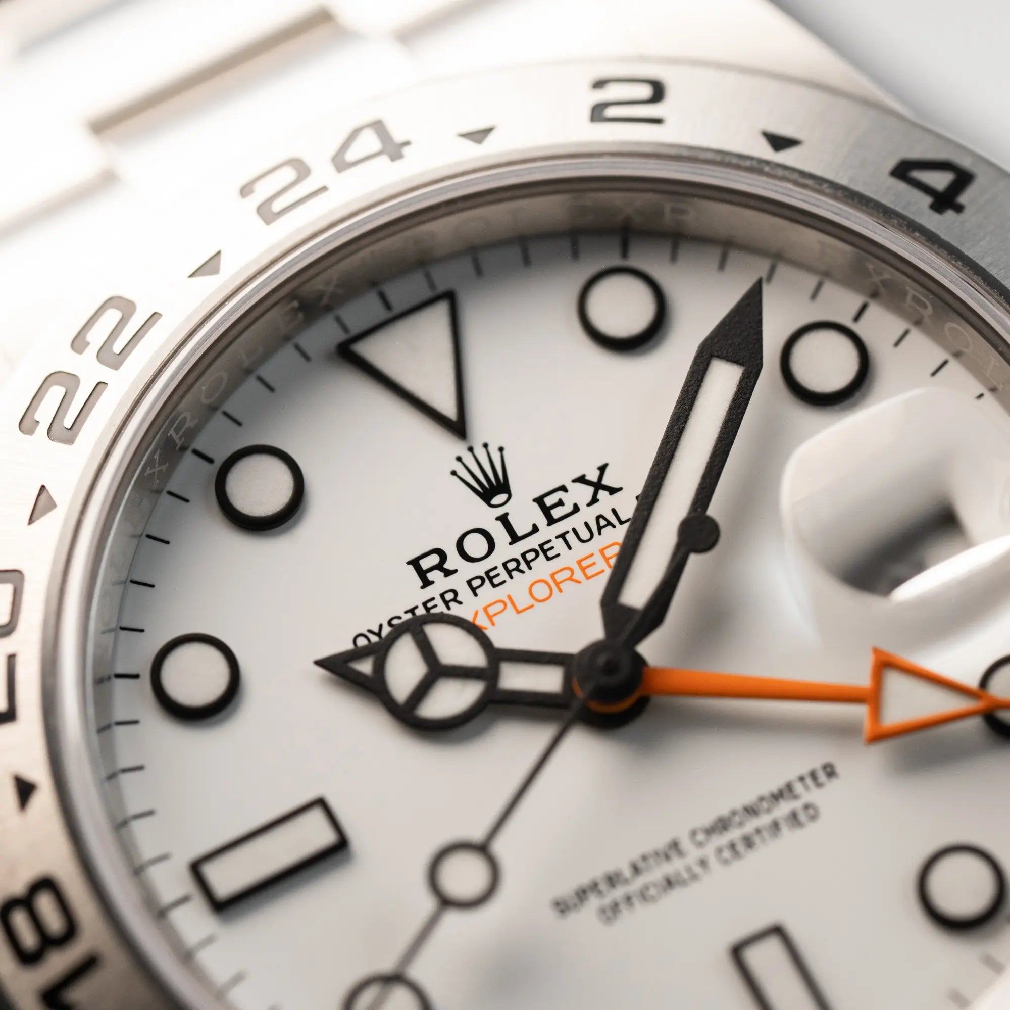 Makroaufnahme des Zifferblatts der Rolex Explorer II im 42mm Oyster-Gehäuse (Referenz 226570) mit weißem Zifferblatt und orangem GMT_Zeiger