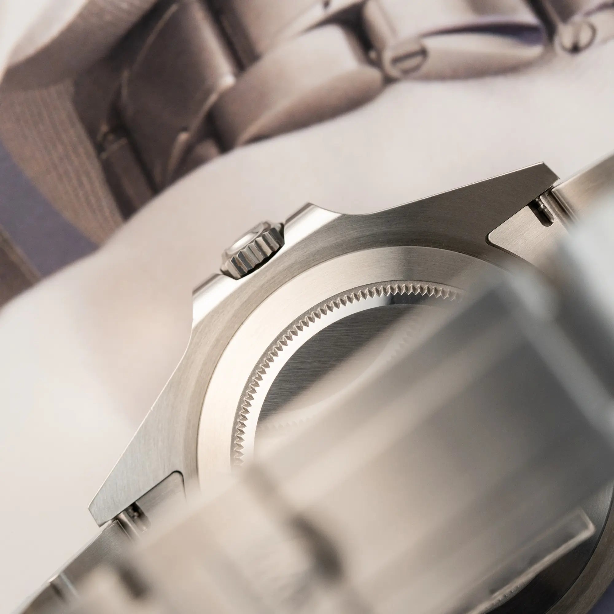 Produktfotografie der Rolex Explorer II im 42mm Oyster-Gehäuse (Referenz 226570) mit weißem Zifferblatt und orangem GMT_Zeiger mit Fokus auf dem Gehäuseboden und der Aufzugskrone