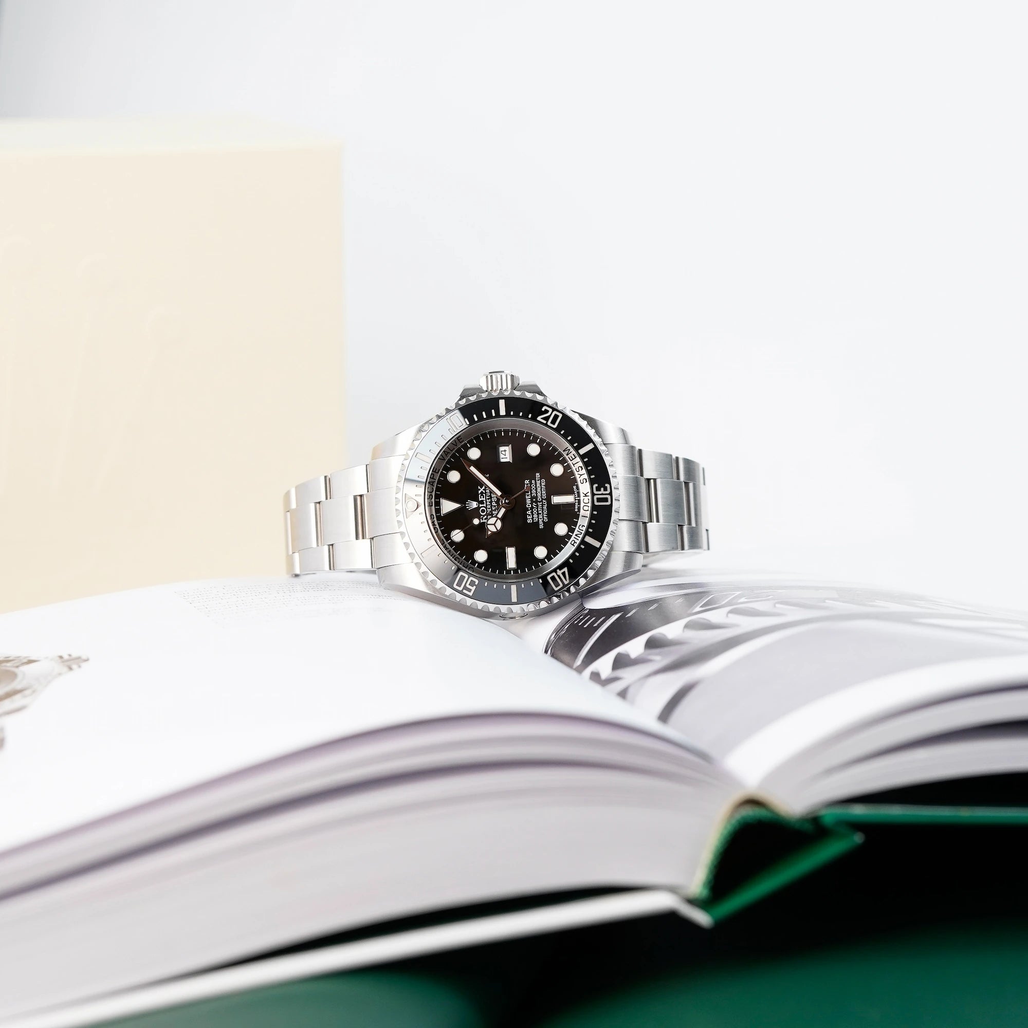 Rolex Sea Dweller Deepsea, Referenz 116660, in Schwarz liegt auf Rolex-Uhrenbuch