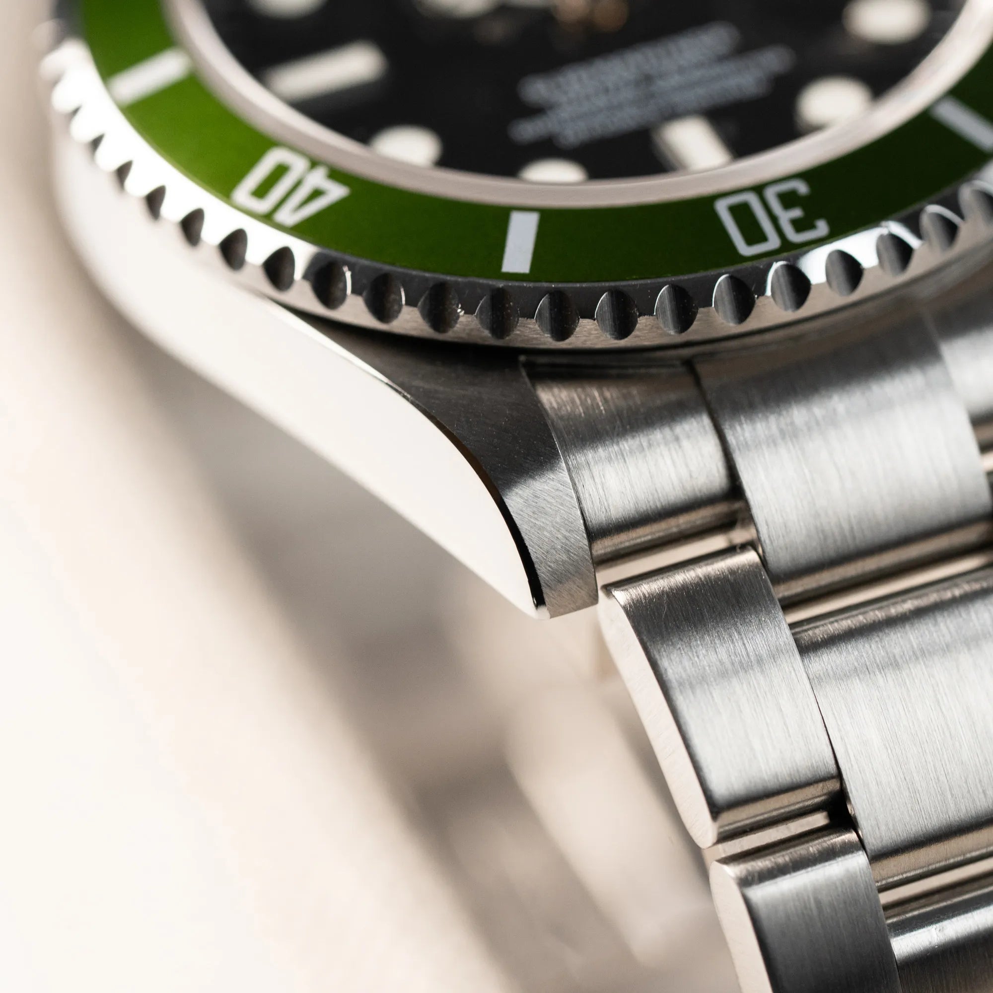 Detailaufnahme des Bandanstoßes der Rolex Submariner Date Taucheruhr in der ikonischen Kermit-Variante mit einer einzigartigen Lime-Lünette