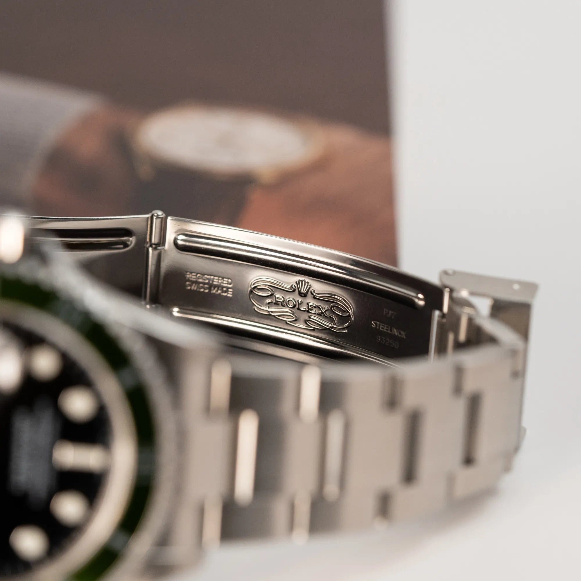 Detailaufnahme des klassischen Rolex Logos in der Faltschliesse von der Rolex Submariner Date Taucheruhr in der ikonischen Kermit-Variante mit einer einzigartigen Lime-Lünette