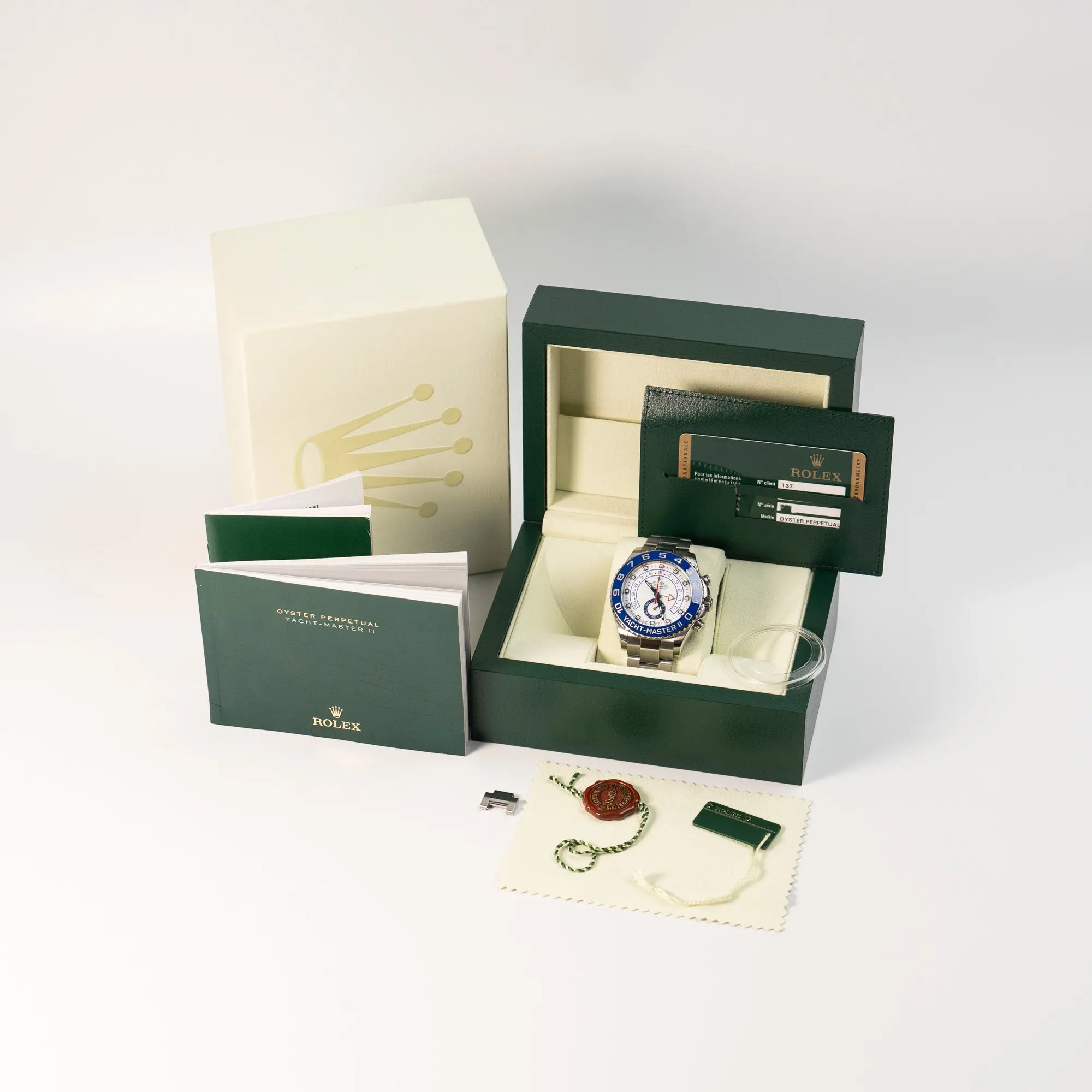 Rolex Yacht-Master 2 mit weißem Zifferblatt und blauer Lynette zusammen mit dem Lieferumfang alsFull-Set, inklusive Box, Papieren, hang-Tag, Lynetten-Schutz, den Bandelementen, sowie Booklets
