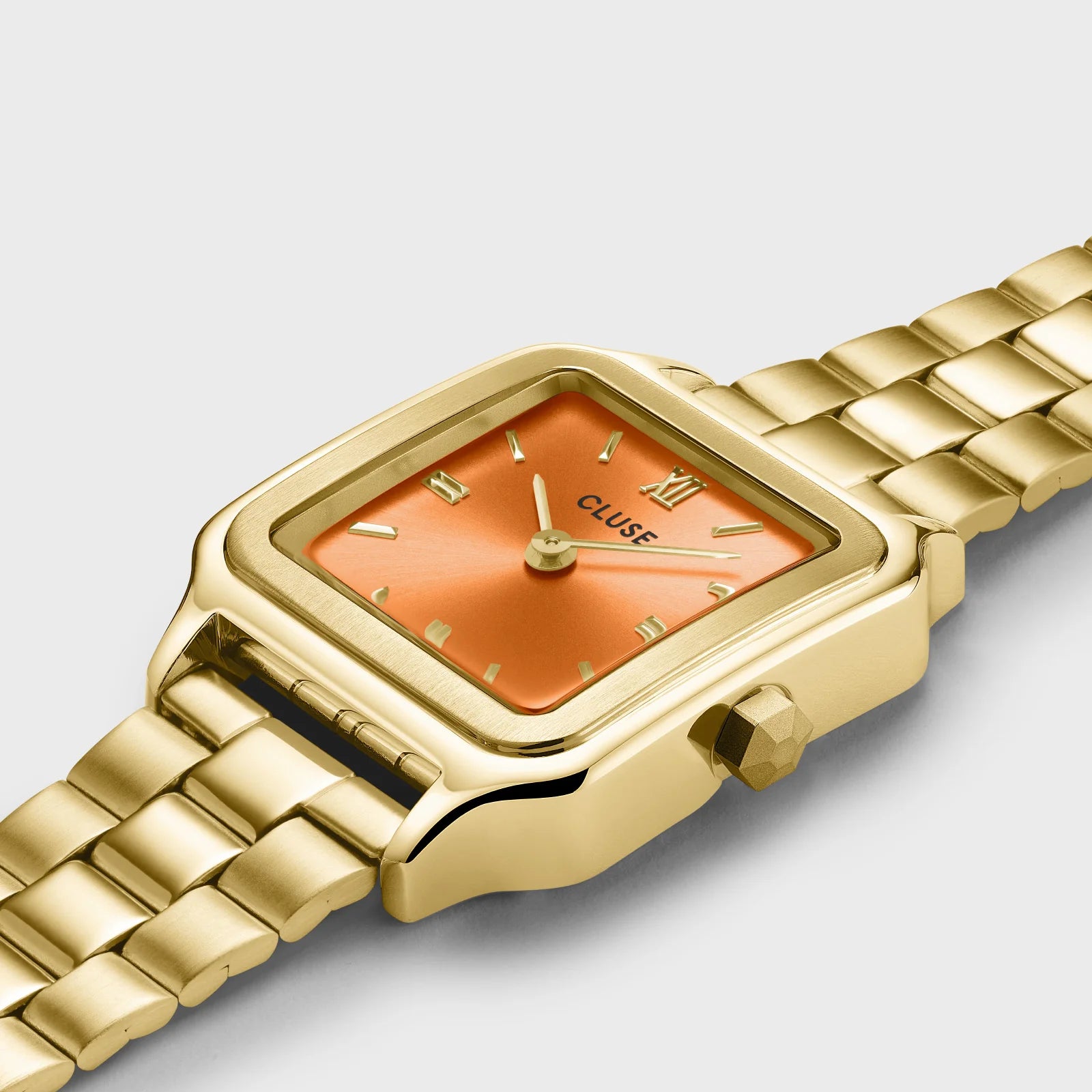 Detailansicht der Cluse Stahl-Uhr "Gracieuse Petite" mit einem gelbgold-farbenem Gehäuse und orangem Zifferblatt