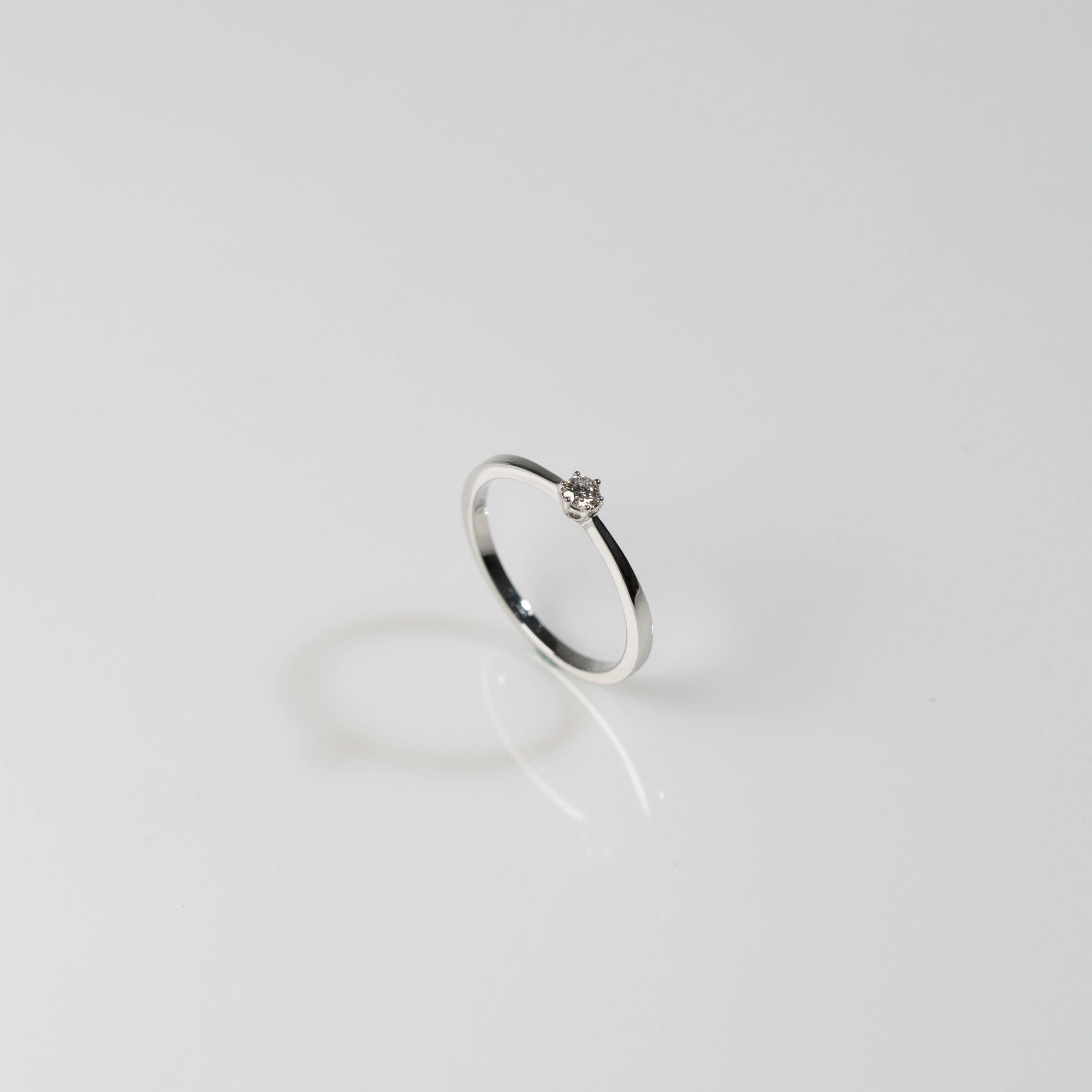 Produktfotografie mit einem Blickwinkel von schräg oben des Weißgold-Verlobungsrings "Promise" aus der Schmuckatelier Lang Collection mit einem in einer 6er Kappe gefassten Diamanten