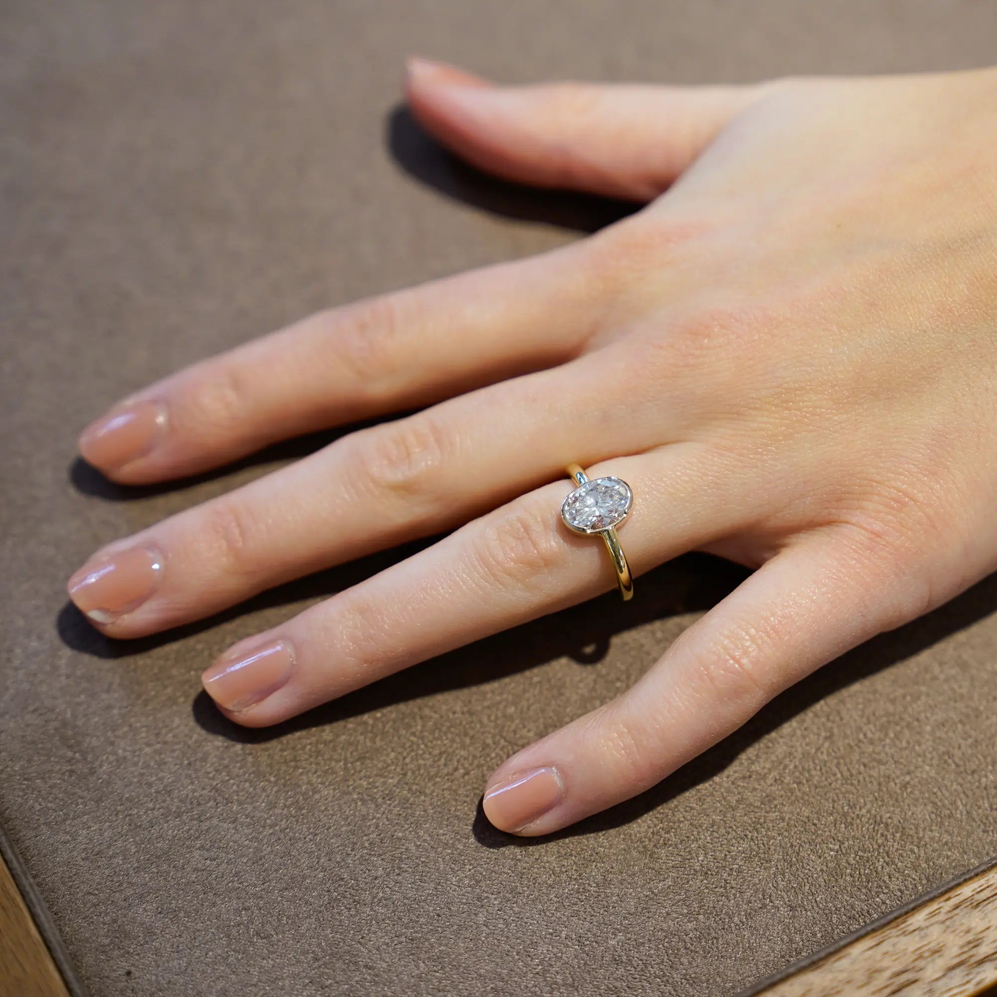 Frau trägt den in Gelbgold gefertigten Verlobungsring "Gleaming Love" mit einem großen Labor-Diamanten mit 2.03ct an Ihrem Ringfinger