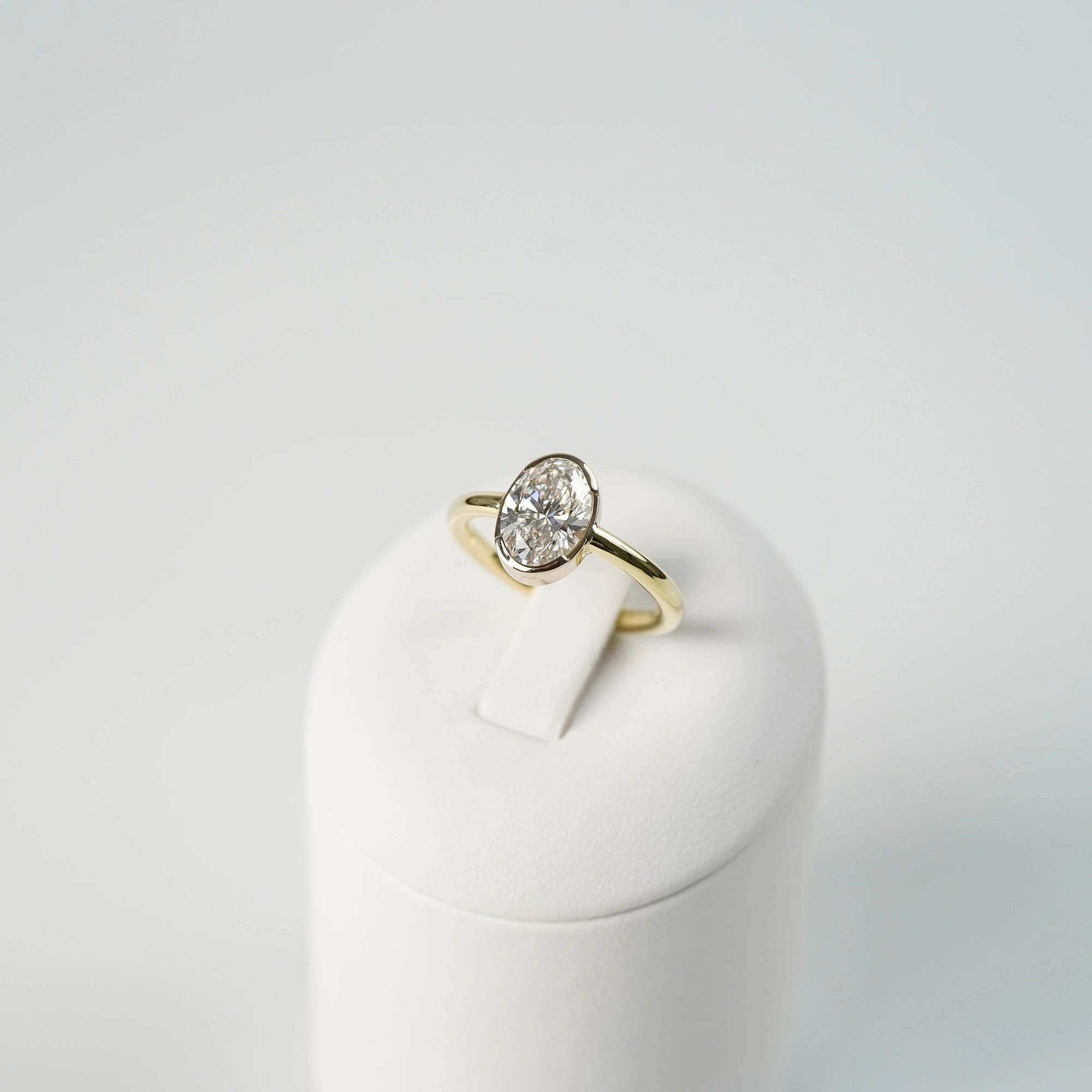 Produktfoto des in Gelbgold gefertigten Verlobungsring "Gleaming Love" mit einem großen Labor-Diamanten mit 2.03ct, während der Ring auf einem Ringständer steckt