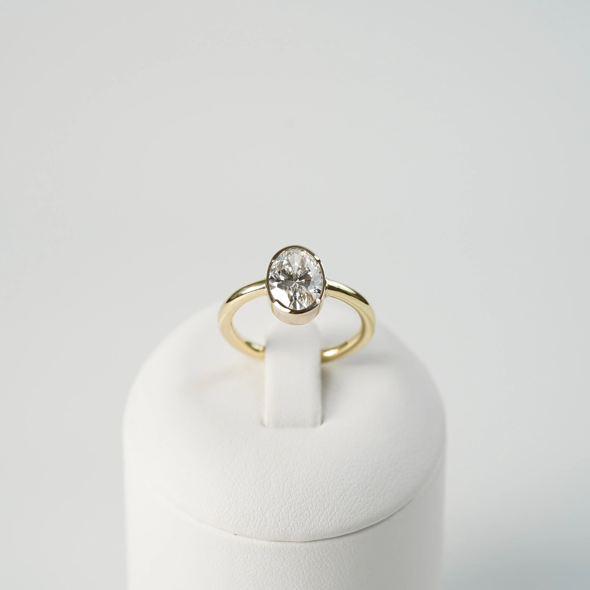 Produktfoto des in Gelbgold gefertigten Verlobungsring "Gleaming Love" mit einem großen Labor-Diamanten mit 2.03ct, während der Ring auf einem Ringständer steckt (frontaler Blickwinkel)