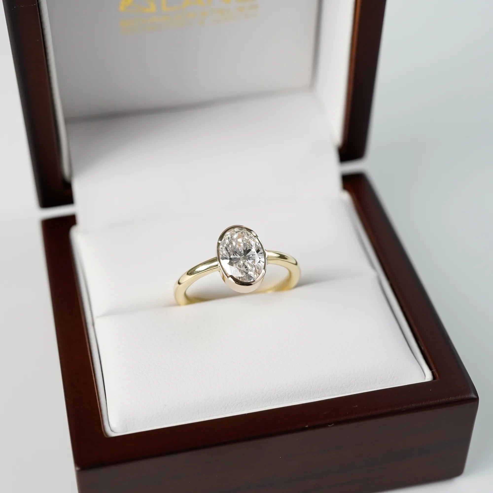 Der in Gelbgold gefertigte Verlobungsring "Gleaming Love" mit einem großen Labor-Diamanten mit 2.03ct steck in dessen hölzerner Schmuck-Verpackung