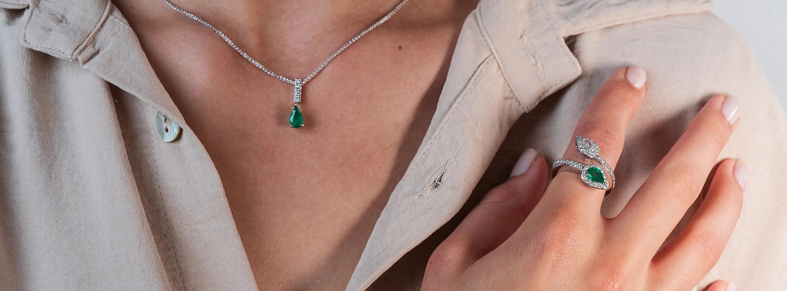 Startseite Bannerbild zeigt eine Dame die Smaragd-Weißgold-Schmuck mit Diamant  trägt