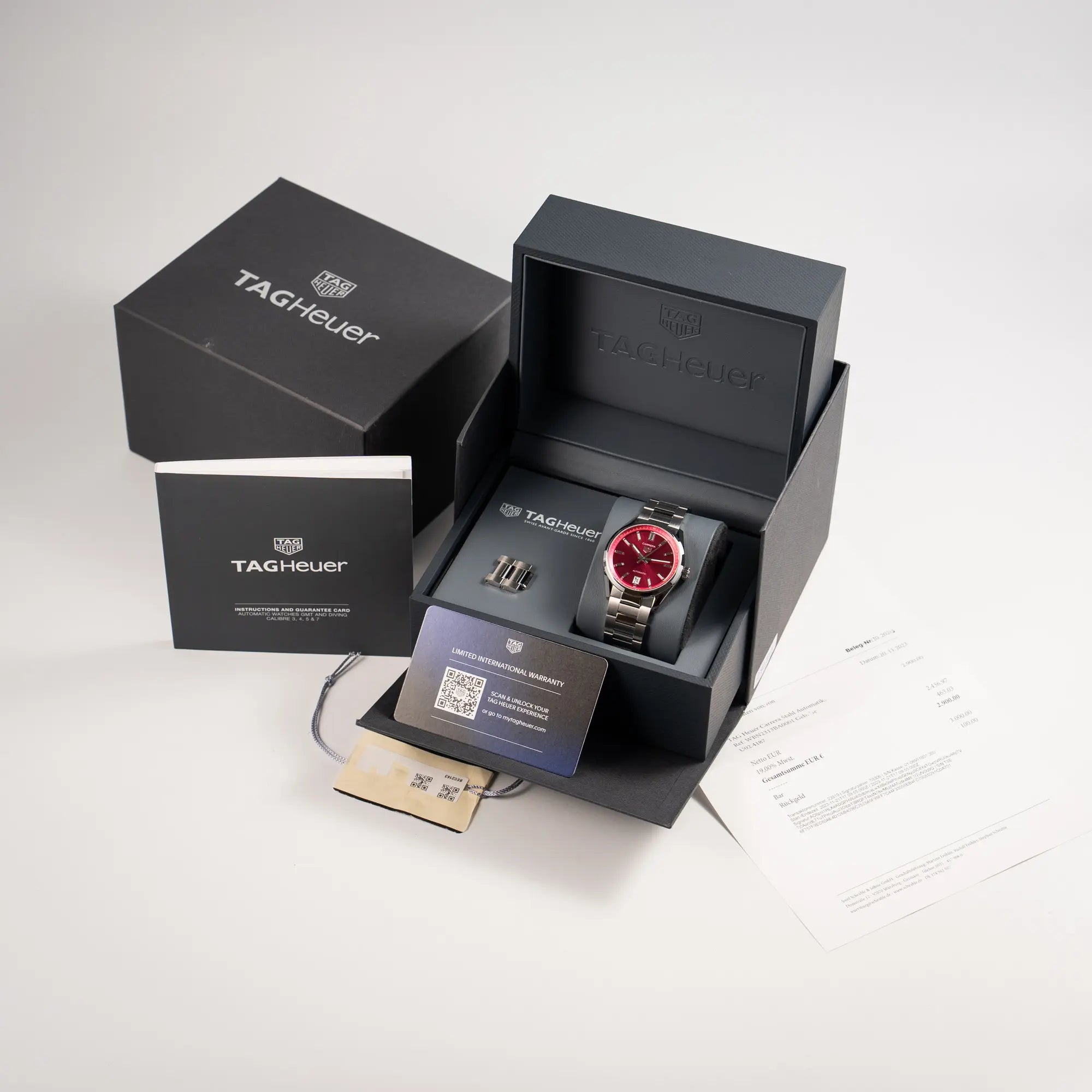 Lieferumfang zu der Tag Heuer Carrera Date Lady mit einem 36mm-Gehäuse und einem markanten pinken Zifferblatt mit Sonnenschliff-Finish, bestehend aus Box mit Umkarton, Garantiekarte, Booklets und Erstkaufrechnung