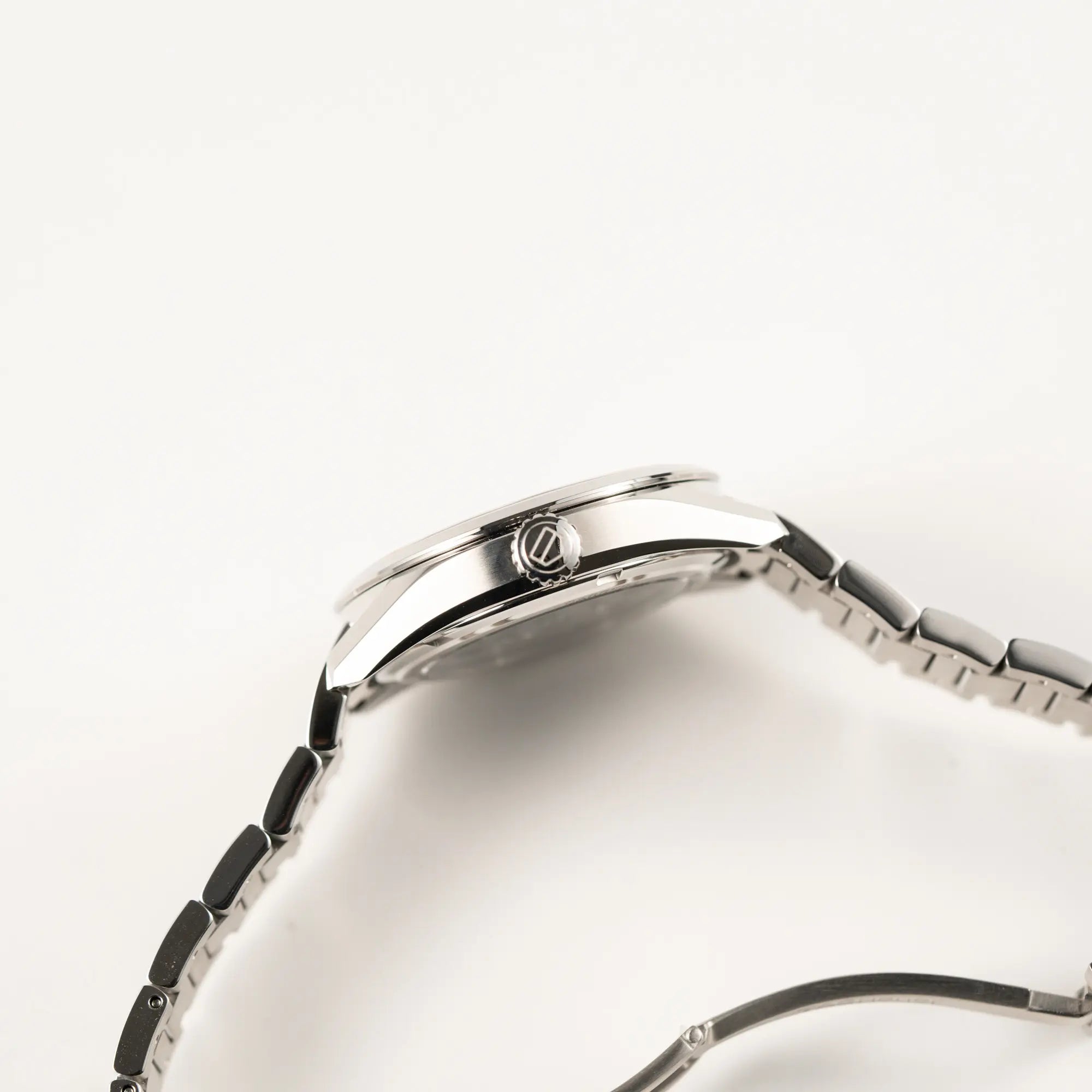 Seitliche Gehäuseflanke der Tag Heuer Carrera Date Lady mit einem 36mm-Gehäuse und einem markanten pinken Zifferblatt mit Sonnenschliff-Finish mit Blick auf die Aufzugskrone