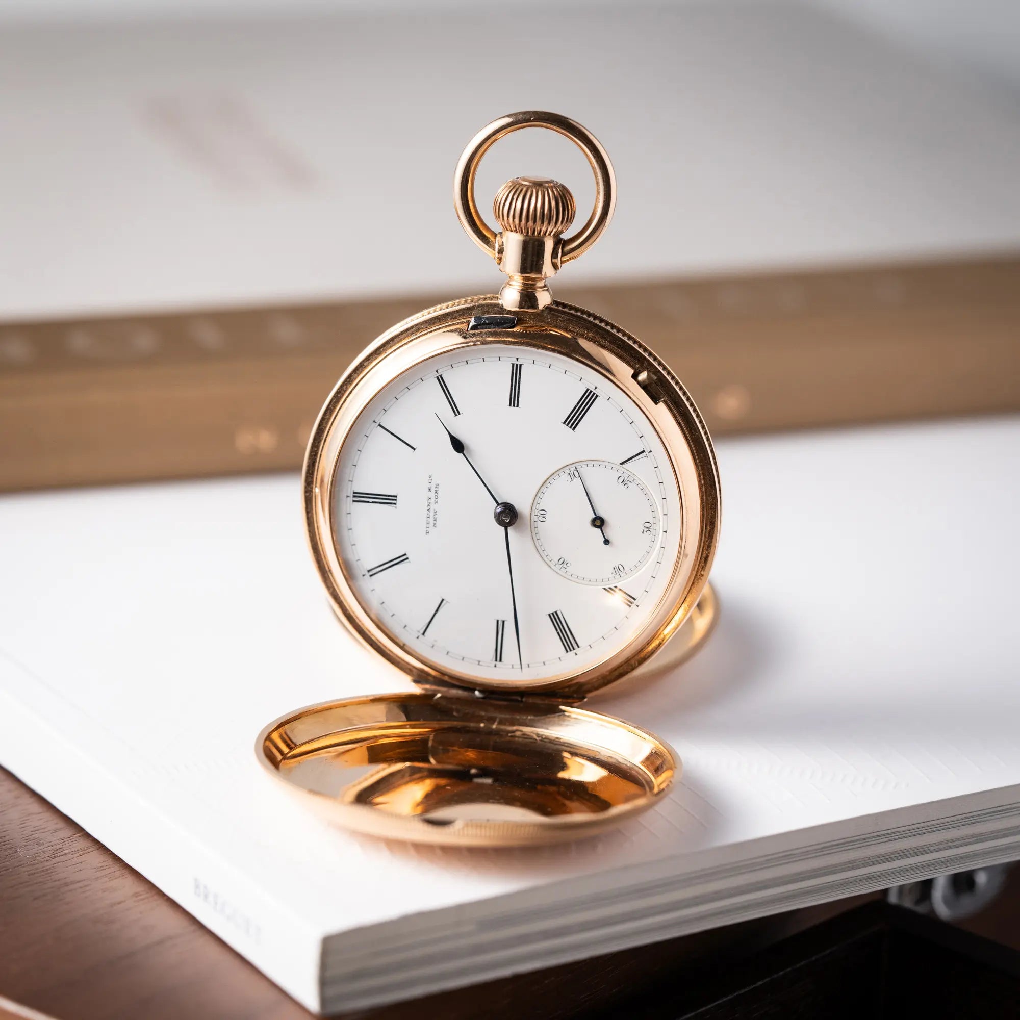 Produktfotografie als Titelbild für die Tiffany & Co Savonette Taschenuhr aus 18k Gelbgold mit weißem Zifferblatt und römischen Indizes