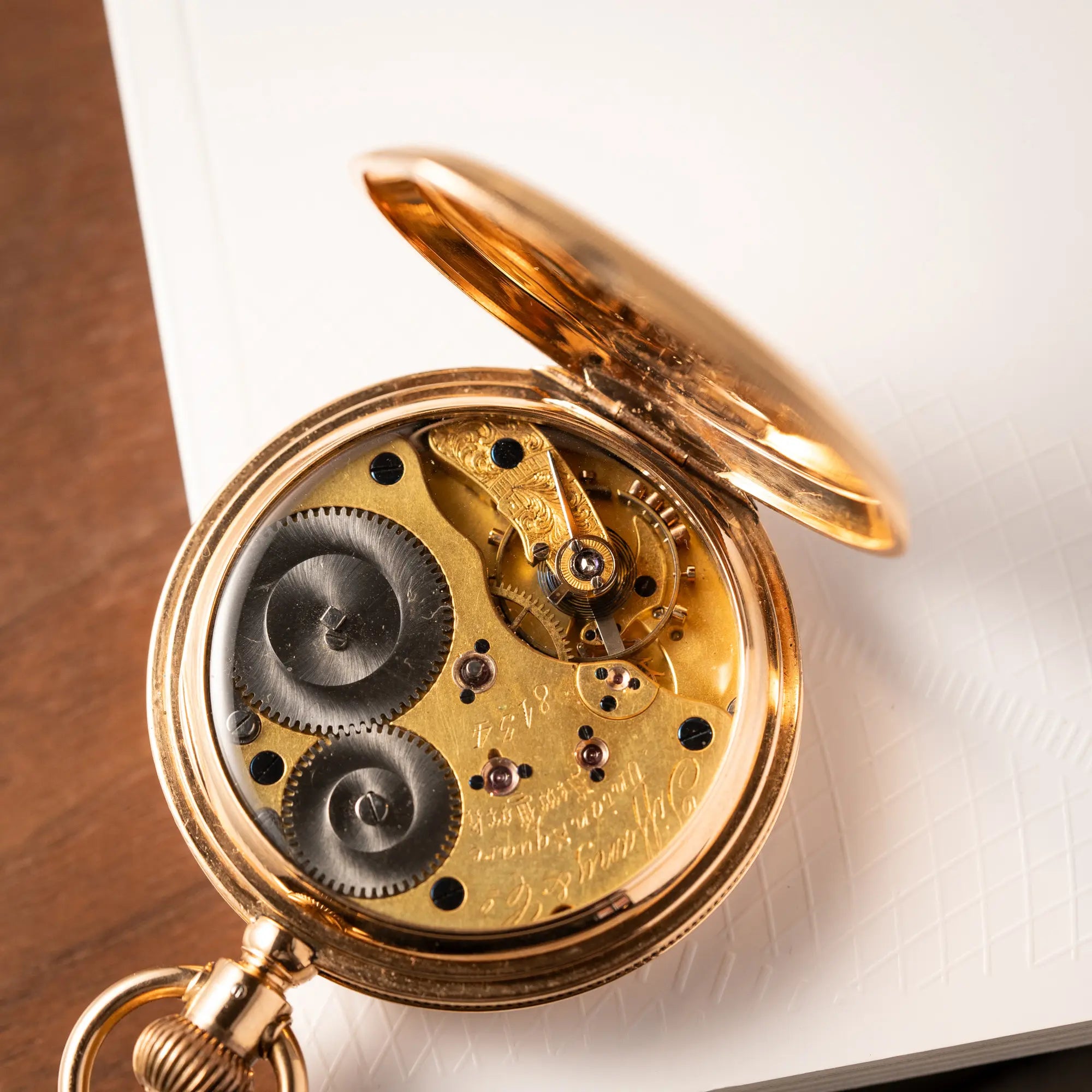 Blick auf das Handaufzugs-Caliber der Tiffany & Co Savonette Taschenuhr aus 18k Gelbgold mit weißem Zifferblatt und römischen Indizes