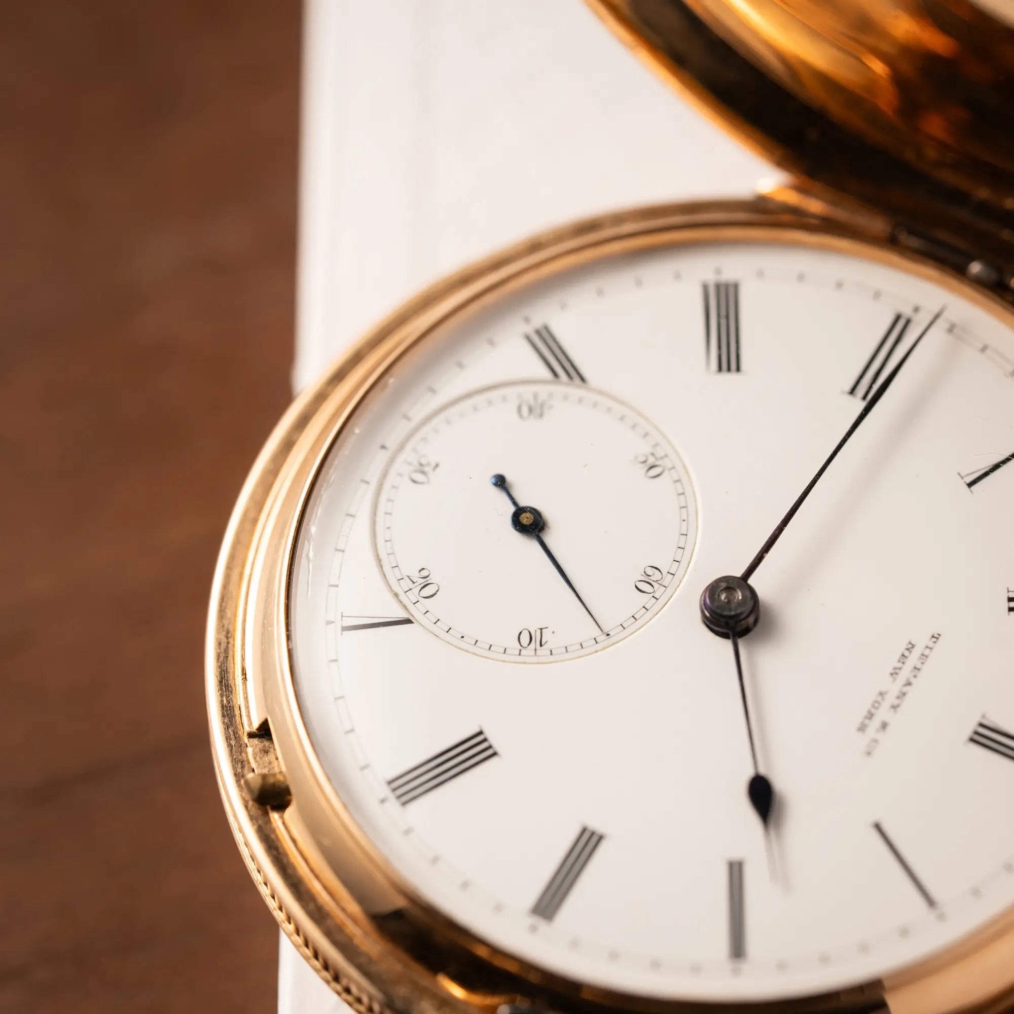Detailaufnahme der kleinen Sekunde von der Tiffany & Co Savonette Taschenuhr aus 18k Gelbgold mit weißem Zifferblatt und römischen Indizes