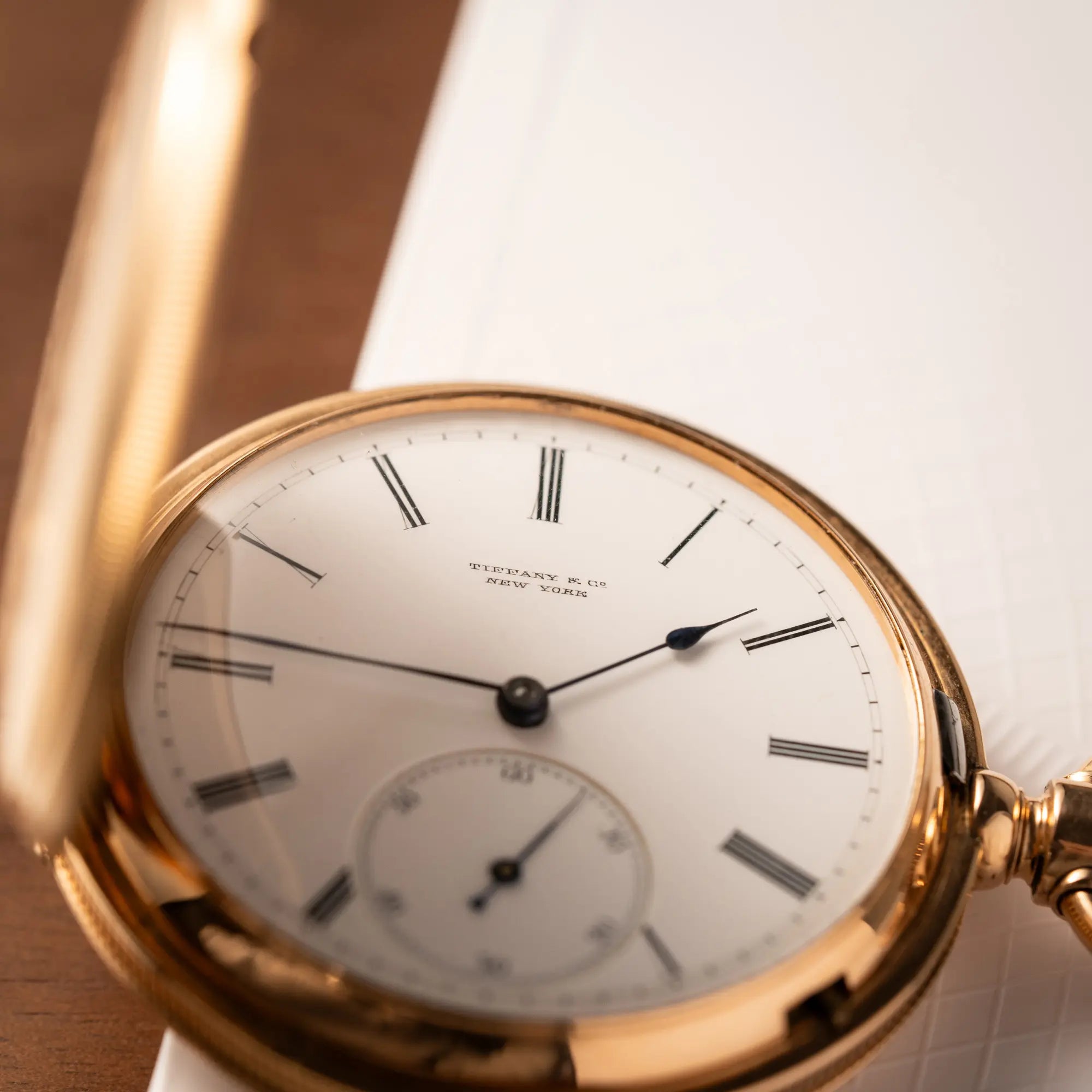 Produktfotografie der Tiffany & Co Savonette Taschenuhr aus 18k Gelbgold mit weißem Zifferblatt und römischen Indizes