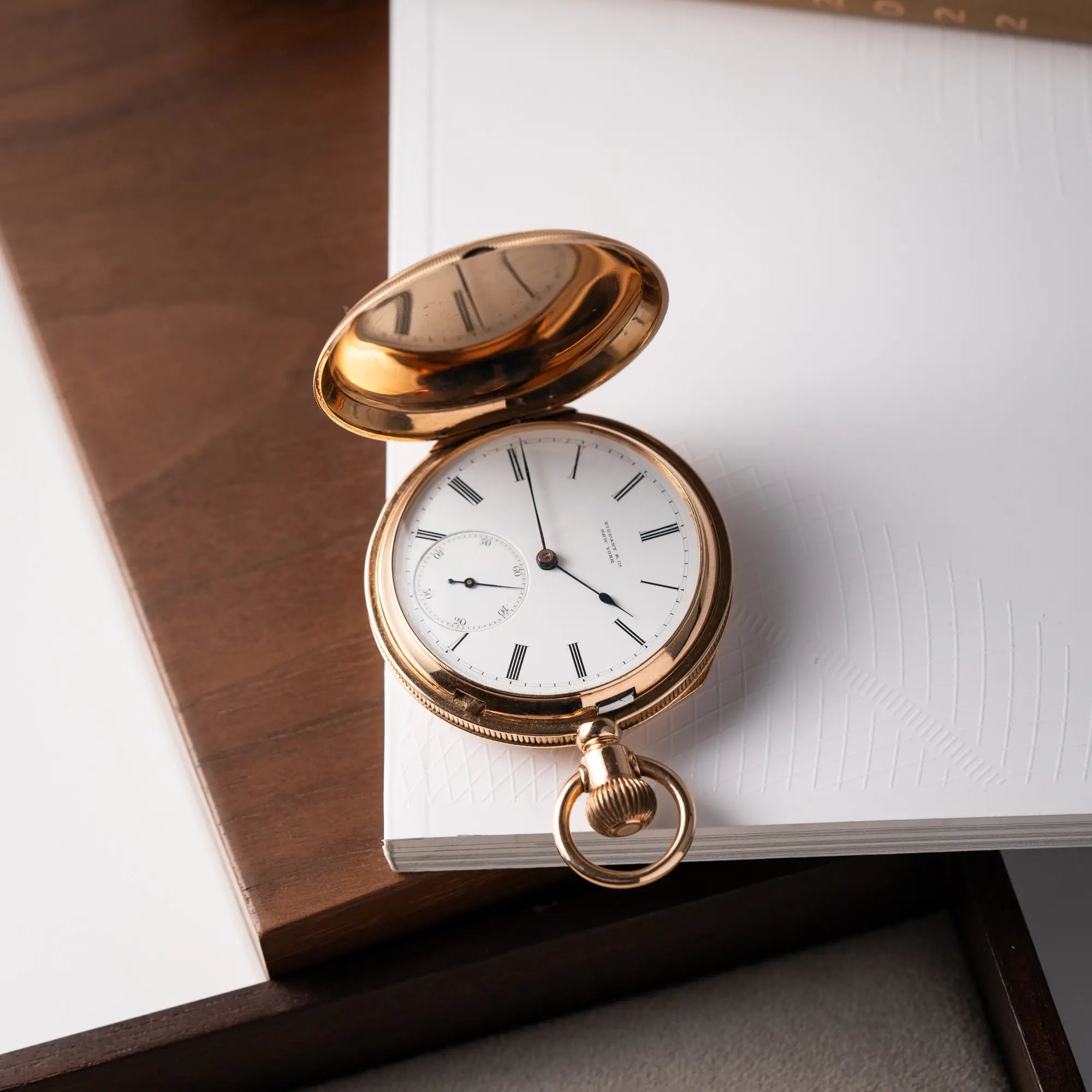 Produktfotografie der Tiffany & Co Savonette Taschenuhr aus 18k Gelbgold mit weißem Zifferblatt und römischen Indizes