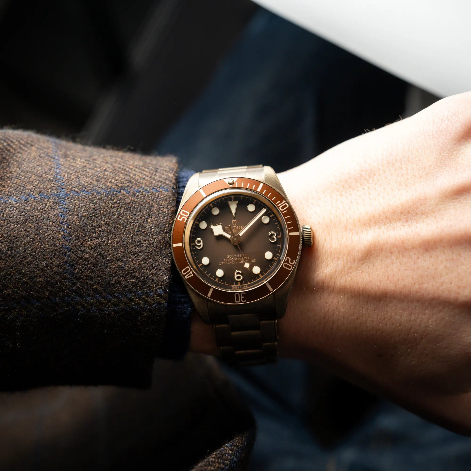 Mann trägt die Tudor Black Bay 58 M79012M in Bronze, deren Oberfläche bereits mit einer gleichmäßigen Patina überzogen ist, mit einem braunem Zifferblatt an seinem Handgelenk