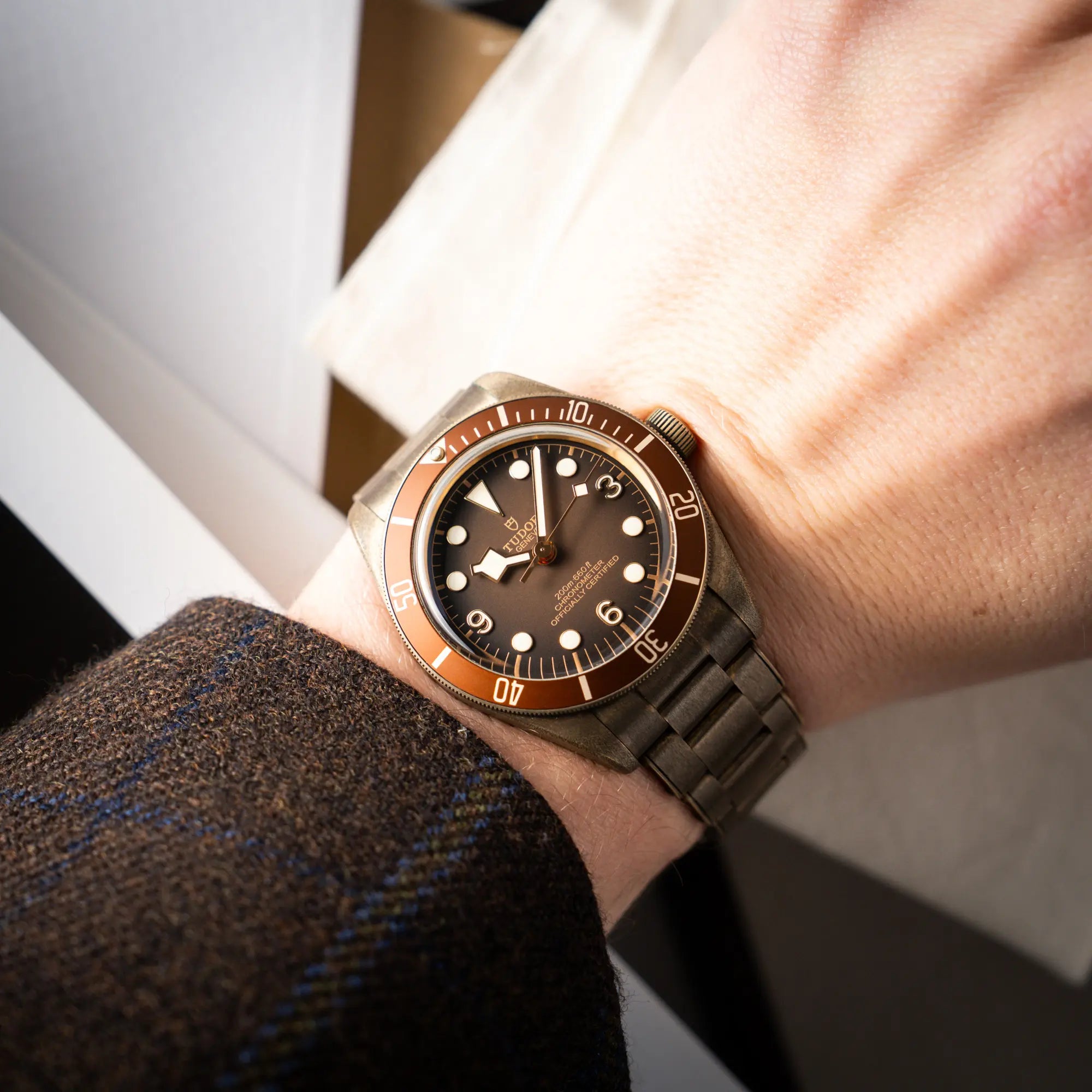 Mann trägt die Tudor Black Bay 58 M79012M in Bronze, deren Oberfläche bereits mit einer gleichmäßigen Patina überzogen ist, mit einem braunem Zifferblatt an seinem Handgelenk