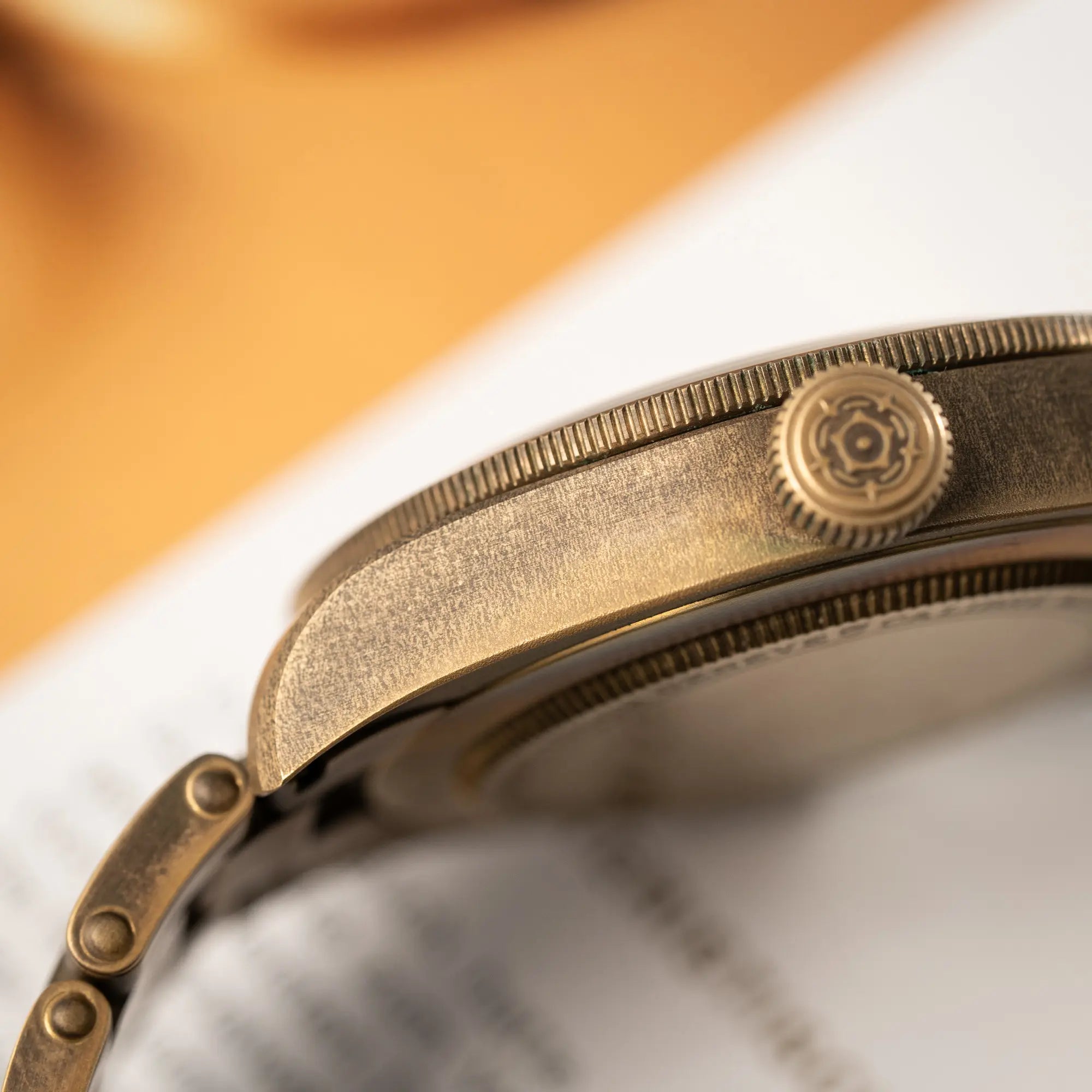 Detailaufnahem der seitlichen Gehäuseflanke mit Blick auf die Aufzugskrone der Tudor Black Bay 58 M79012M in Bronze, deren Oberfläche bereits mit einer gleichmäßigen Patina überzogen ist, mit einem braunem Zifferblatt