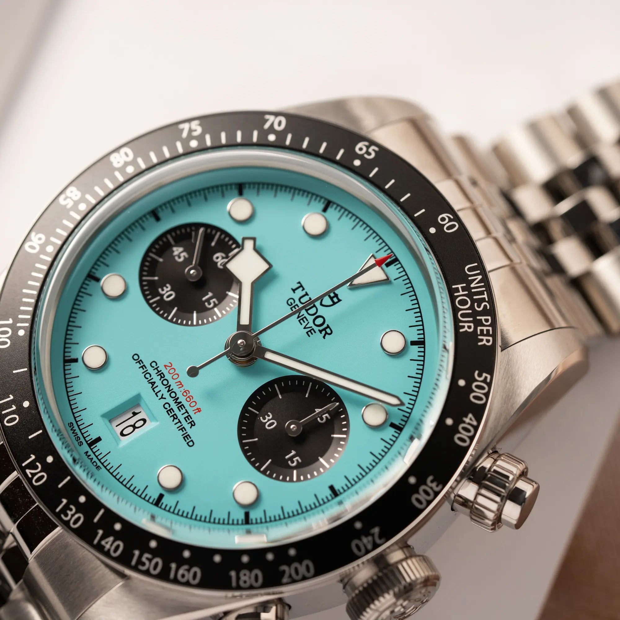 Detailaufnahme des Tudor Black Bay Chronograph Flamingo mit dem türkis-blauen Zifferblatt mit schwarzen Totalisatoren und schwarzer Lünette mit Zähler-Skala