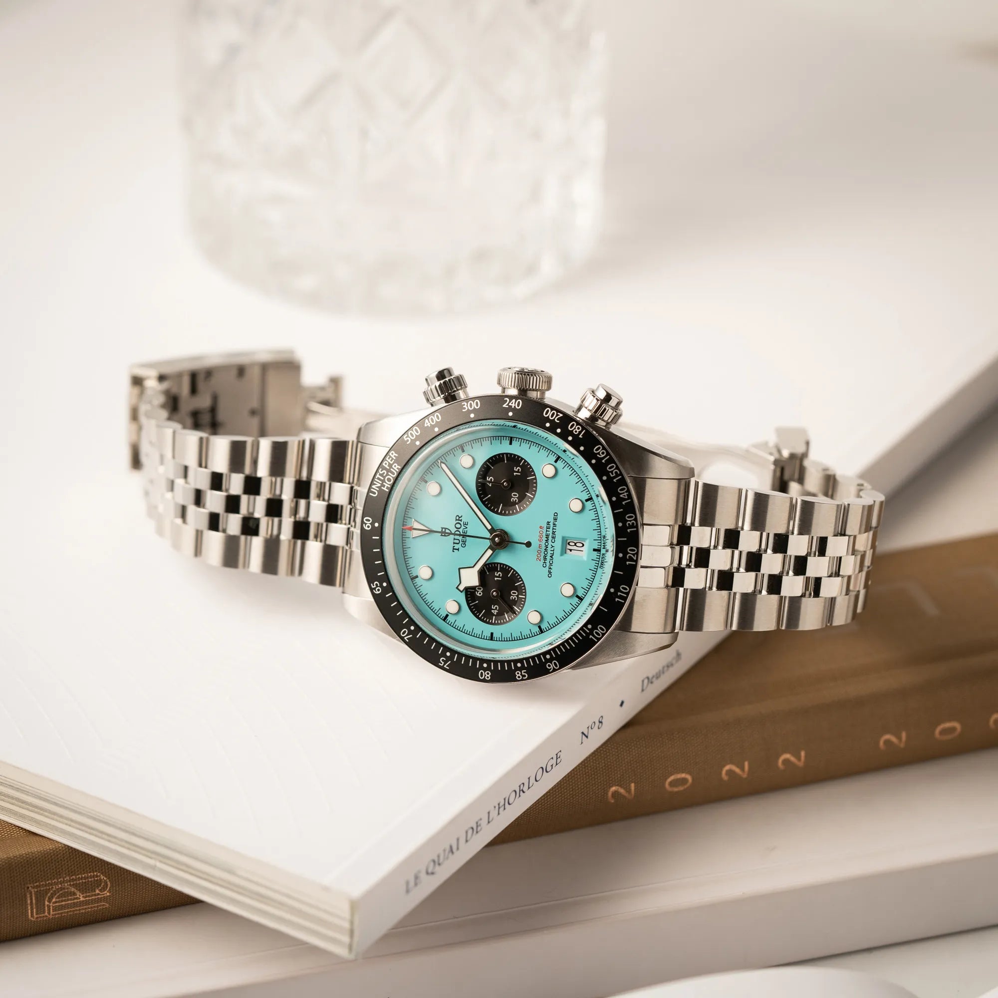 Produktfotografie von dem Tudor Black Bay Chronograph Flamingo mit dem türkis-blauen Zifferblatt mit schwarzen Totalisatoren und schwarzer Lünette mit Zähler-Skala