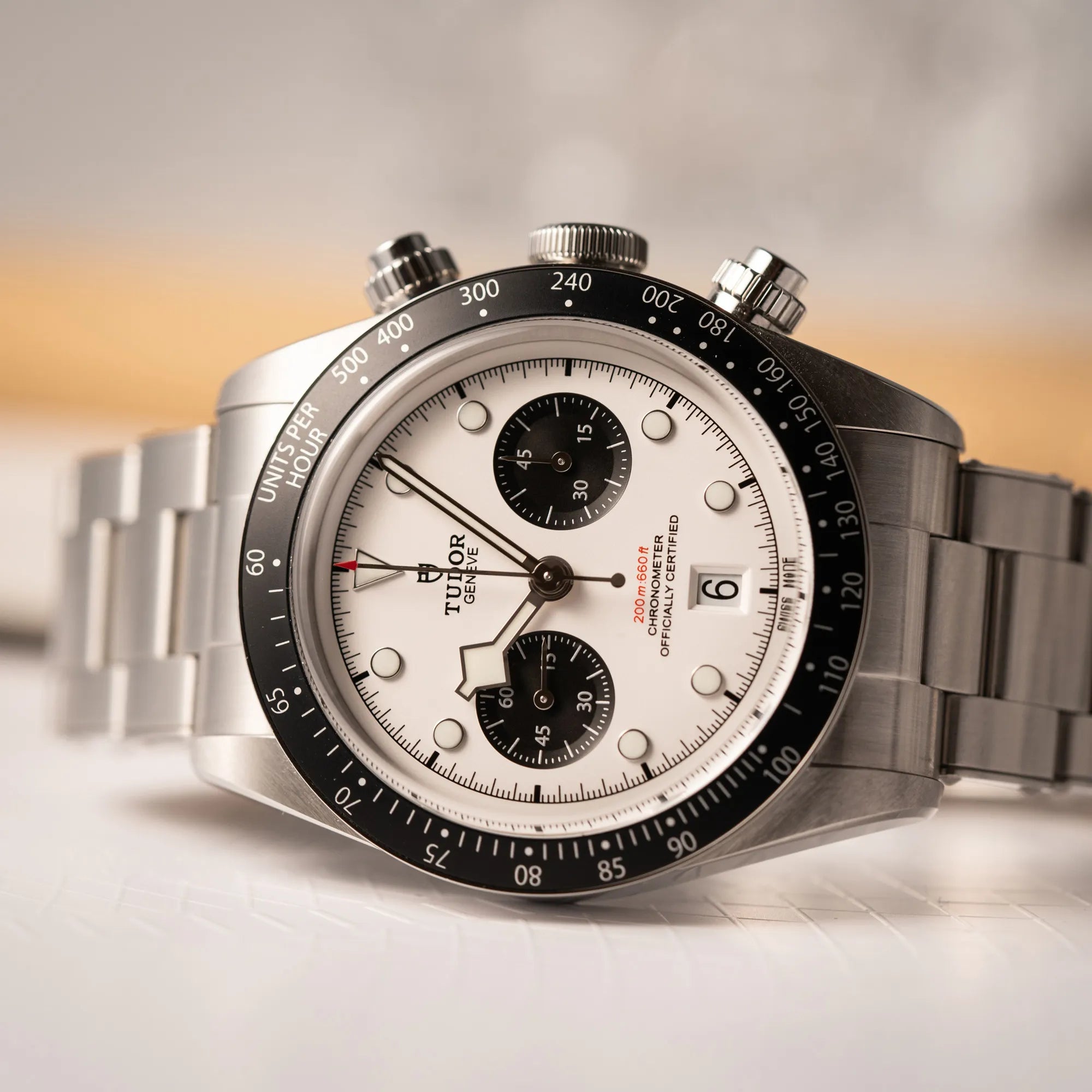 Produktfotografie zeigt den seitlich liegenden Uhrenkopf des Tudor Black Bay Chronograph 79360N mit dem Panda-Zifferblatt in weiß mit schwarzen Totalisatoren