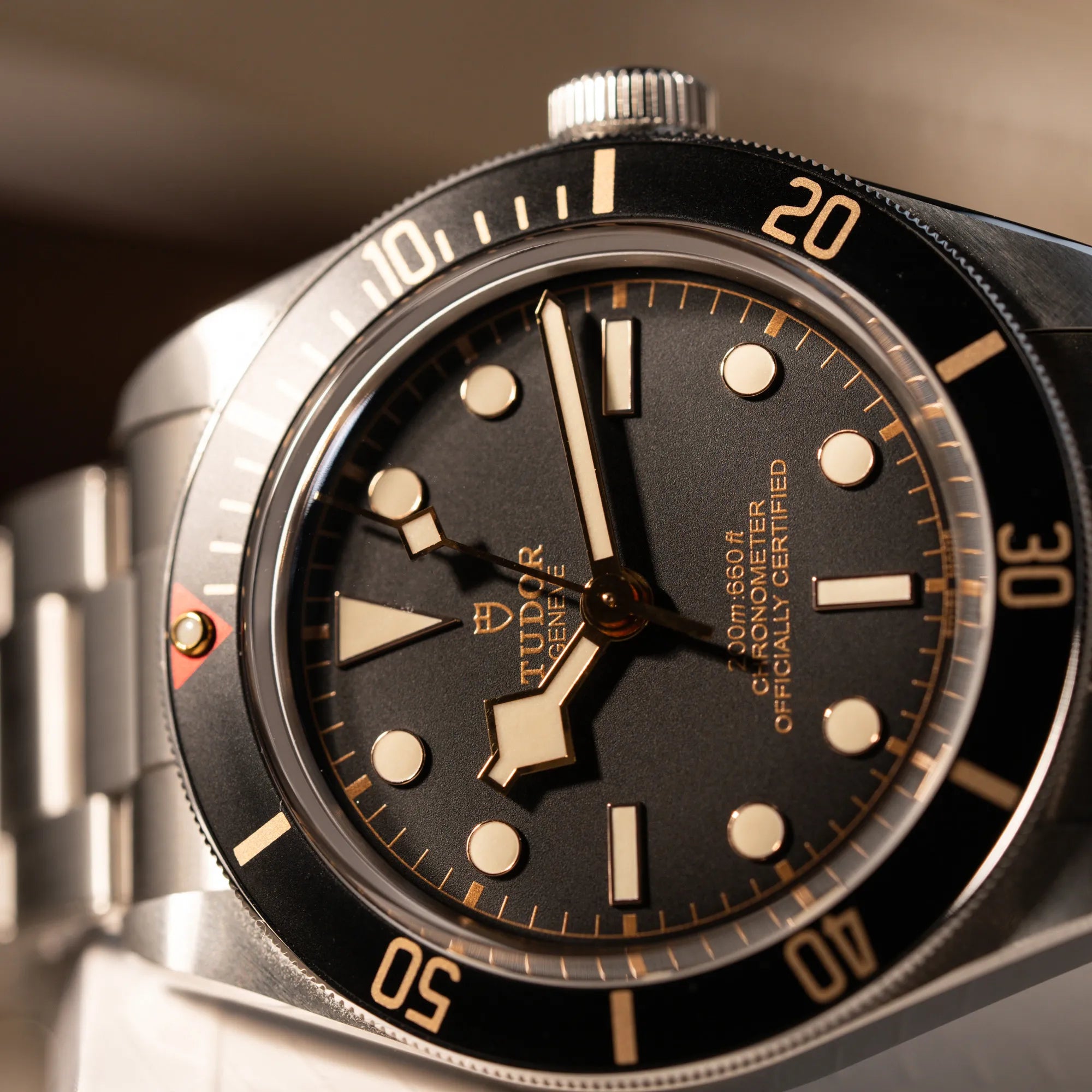 Detailaufnahme des Uhrenkopfes der Tudor Black Bay Fiftyeight in Edelstahl mit schwarzem Zifferblatt und bronzefarbenen Details