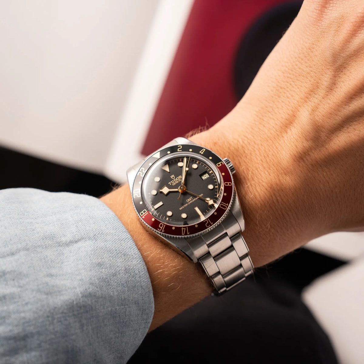 Mann trägt die Tudor BlackBay GMT Coke der Referenz 7939G1A0NRU mit der schwarz-roten Lünette und bronzefarbenen Details am Edelstahlarmband an seinem Handgelenk