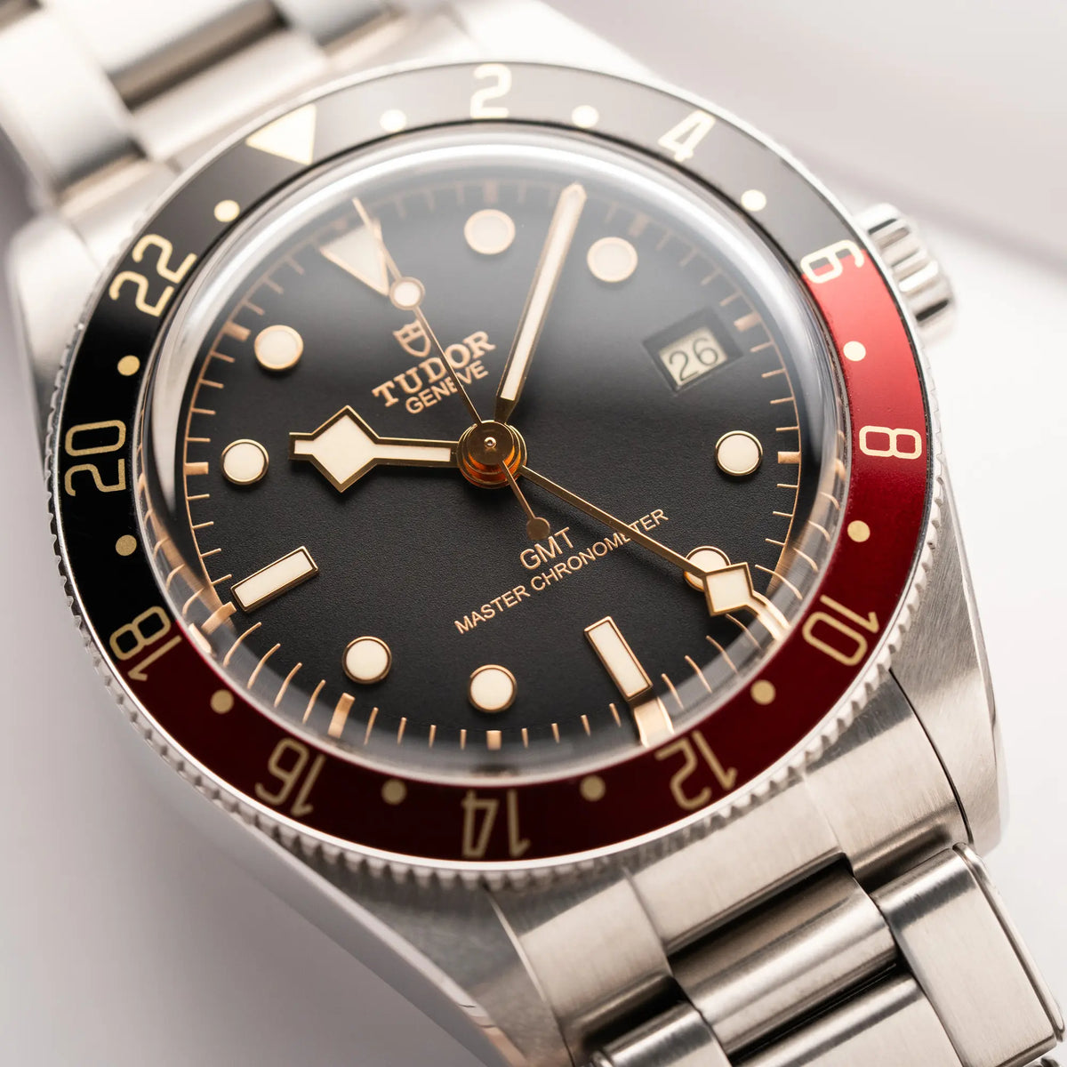 Produktfotografie zeigt den Uhrenkopf der Tudor BlackBay GMT Coke der Referenz 7939G1A0NRU mit der schwarz-roten Lünette und bronzefarbenen Details am Edelstahlarmband 