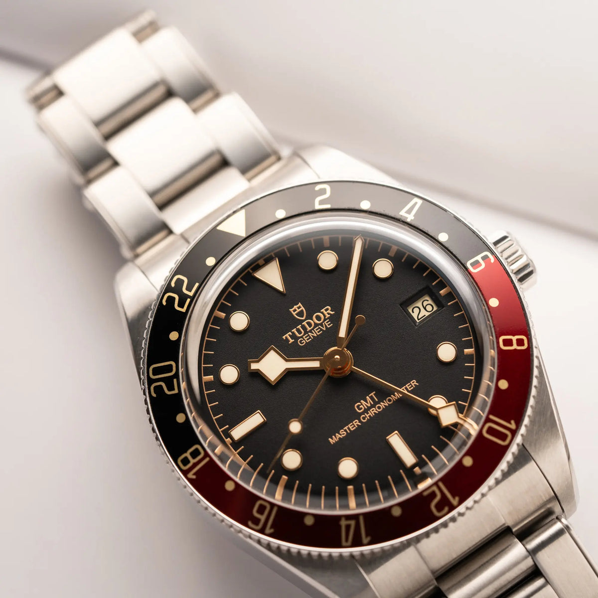 Produktfotografie der Tudor BlackBay GMT Coke der Referenz 7939G1A0NRU mit der schwarz-roten Lünette und bronzefarbenen Details am Edelstahlarmband 