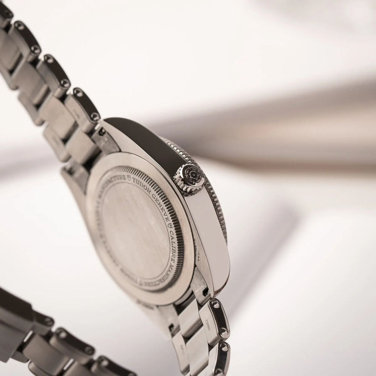 Seitliche Gehäuseflanke der Tudor BlackBay GMT Coke der Referenz 7939G1A0NRU mit der schwarz-roten Lünette und bronzefarbenen Details am Edelstahlarmband mit Blick auf die AUfzugskrone