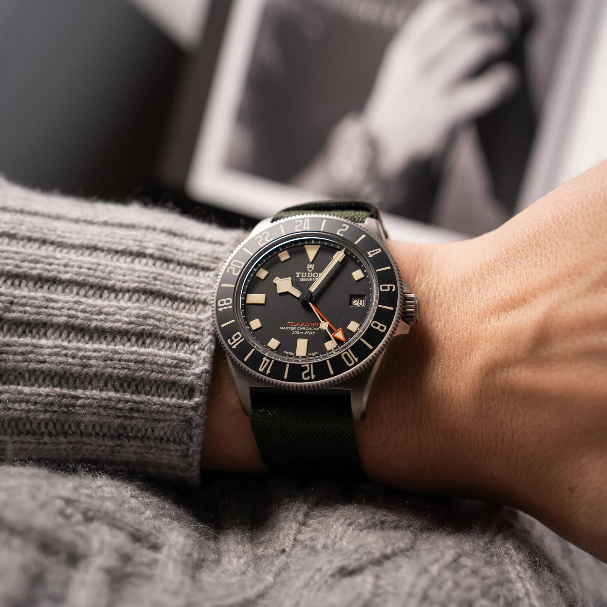Mann trägt die Tudor Pelagos GMT Military der Referenz M2542G257NU-0002 mit Titan-Gehäuse und schwarzem Zifferblatt an einem olivgrünen Nato-Strap für einen Wristshot an seinem Handgelenk