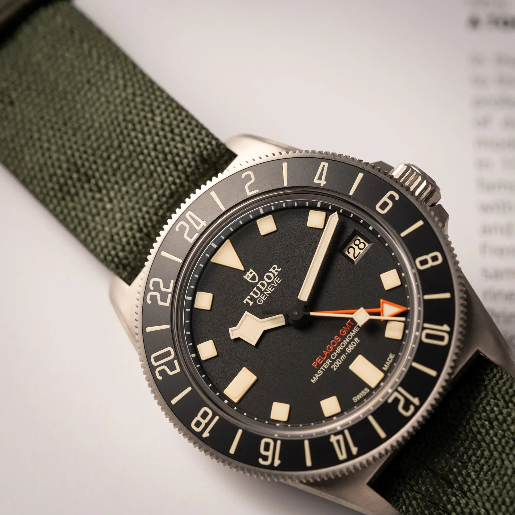 Detailaufnahme des Uhrenkopfes der Tudor Pelagos GMT Military der Referenz M2542G257NU-0002 mit Titan-Gehäuse und schwarzem Zifferblatt an einem olivgrünen Nato-Strap
