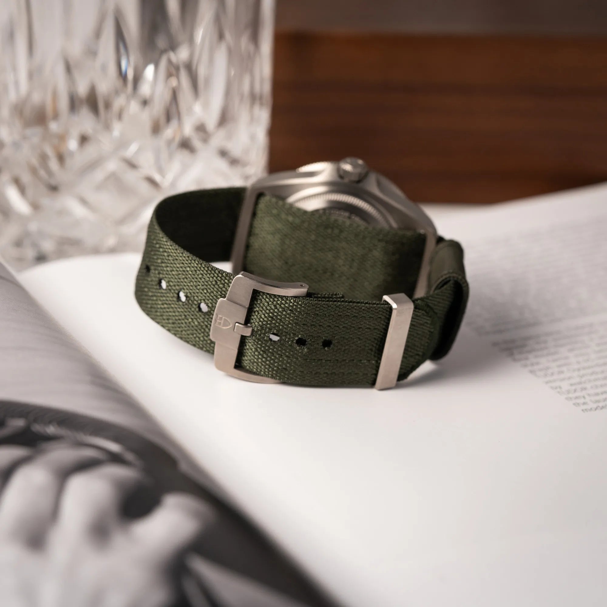 Produktfotografie der Tudor Pelagos GMT Military der Referenz M2542G257NU-0002 mit Titan-Gehäuse und schwarzem Zifferblatt zeigt die originale Dornschliesse an dem olivgrünen Nato-Strap